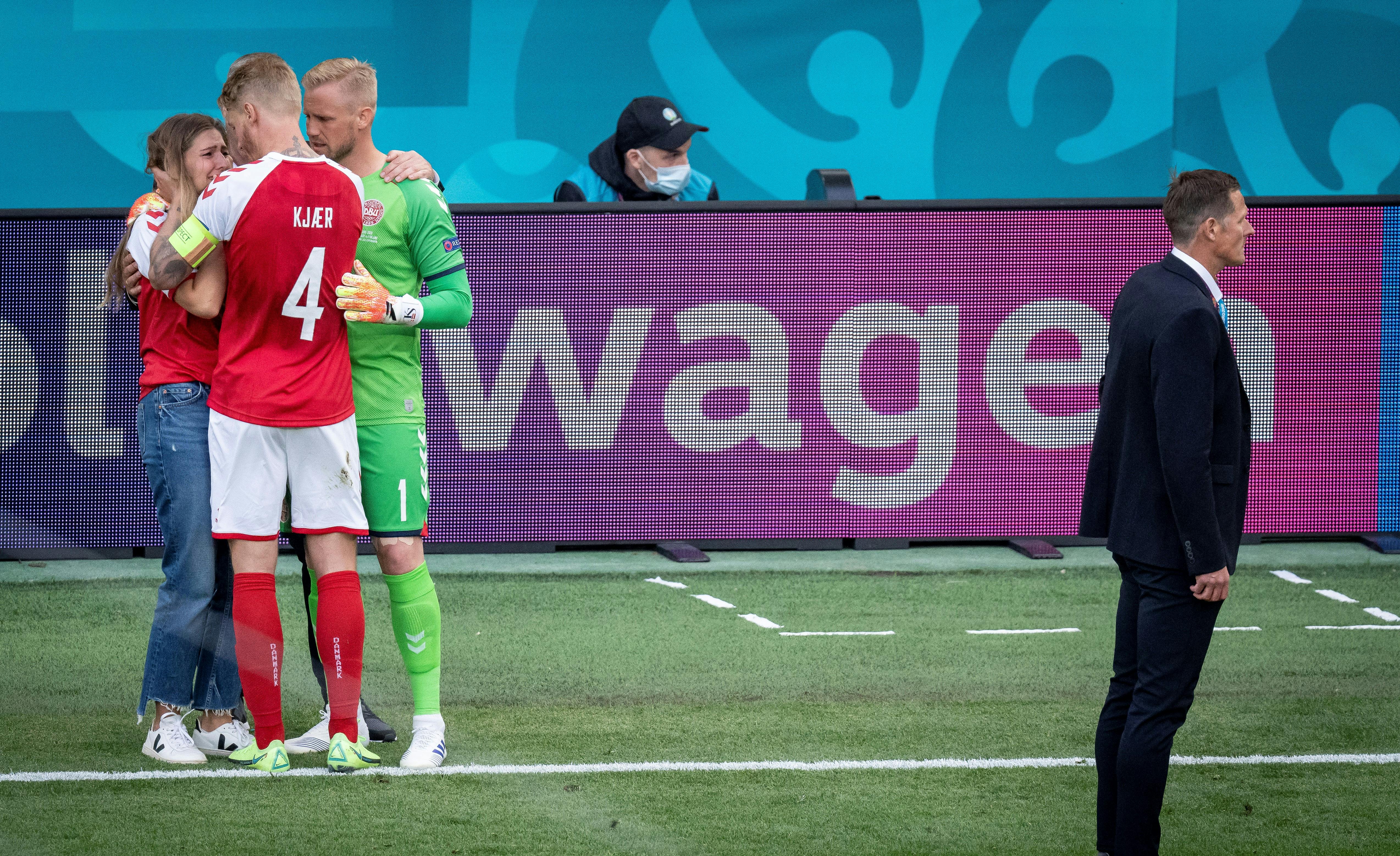 Kasper Schmeichel og Simon Kjær løb Eriksens kæreste Sabrina Kvist Jensen i møde på banen. Hun forlod instinktivt sin plads på publikumsrækkerne, før hun panisk satte i løb mod sin kollapsede kæreste. 