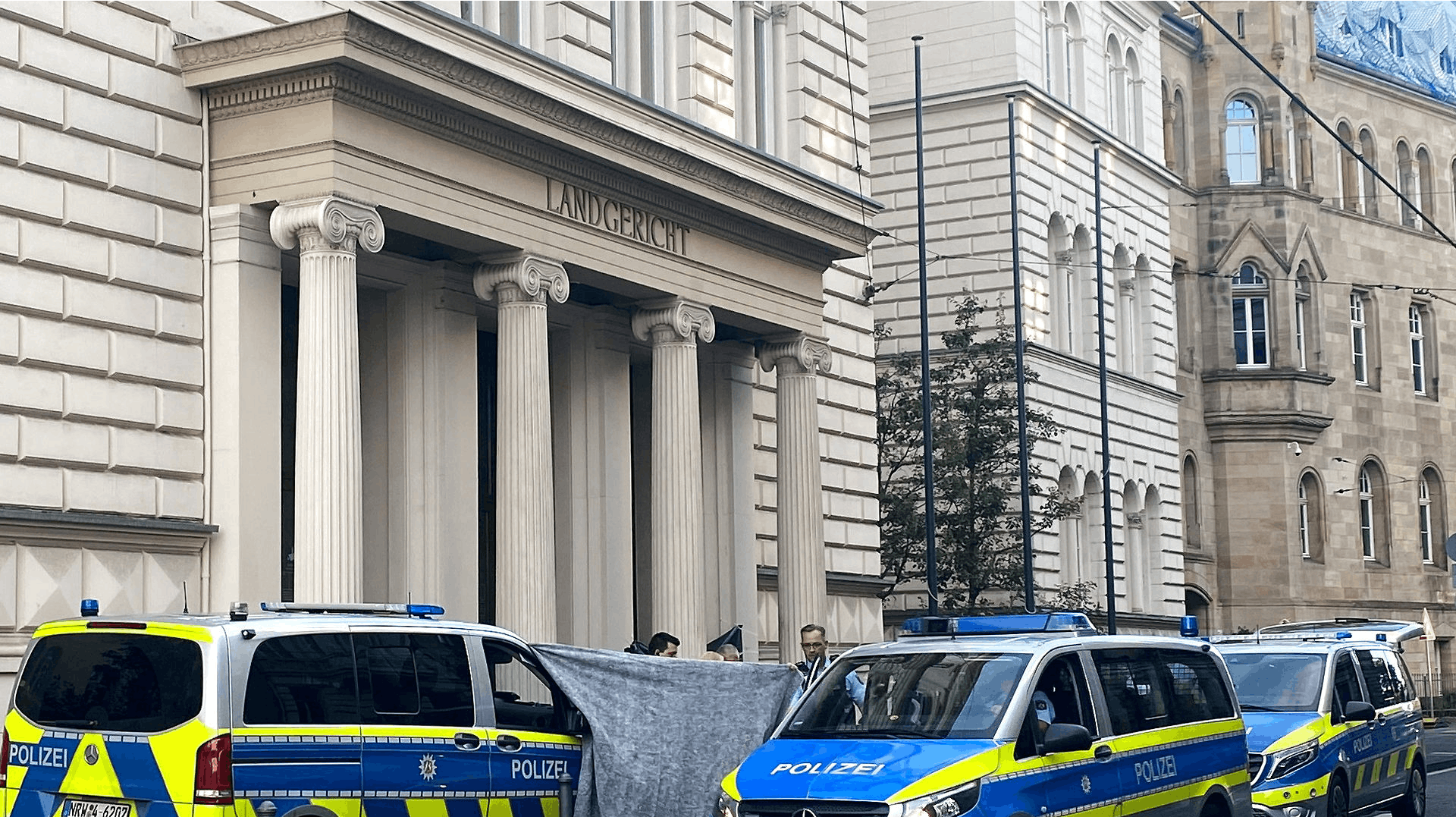 Det afskårne hoved blev fundet ude foran retsbygningen her i den tyske by Bonn. På fotoet er politiet igang med at sikre gerningsstedet.
