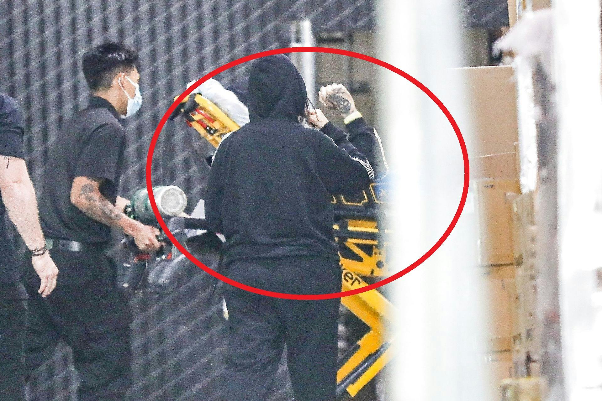 Her ses Travis Barker blive ført ud i en ambulance, mens Kourtney Kardashian følger trop i en sort hættetrøje.
