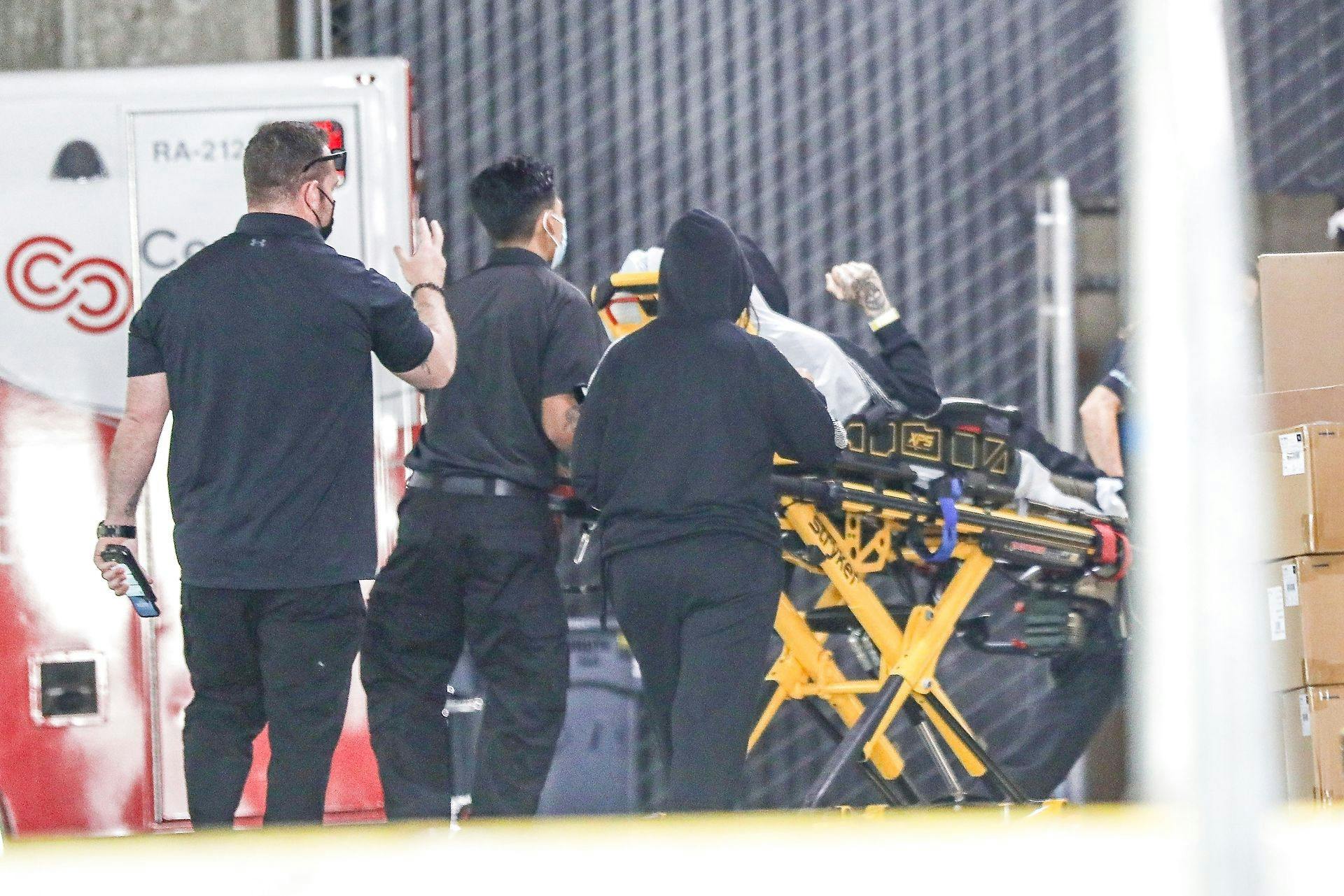 Her bliver Travis Barker kørt bort på en båre. Kourtney Kardashian kan ses med ryggen til i en sort hættetrøje.
