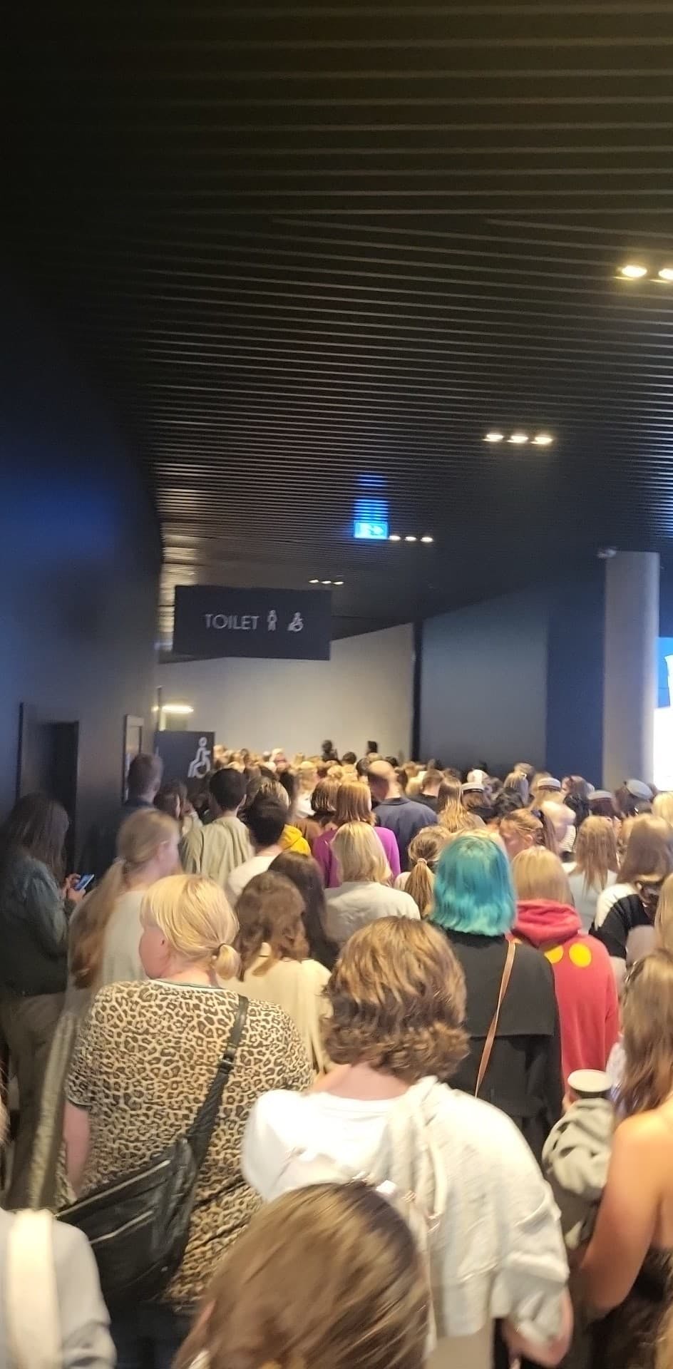 Fans strømmer mod udgangene, mens flere græder. De nåede at vente længe på sæderækkerne, før popidolet Harry Styles' koncert blev endeligt aflyst. 