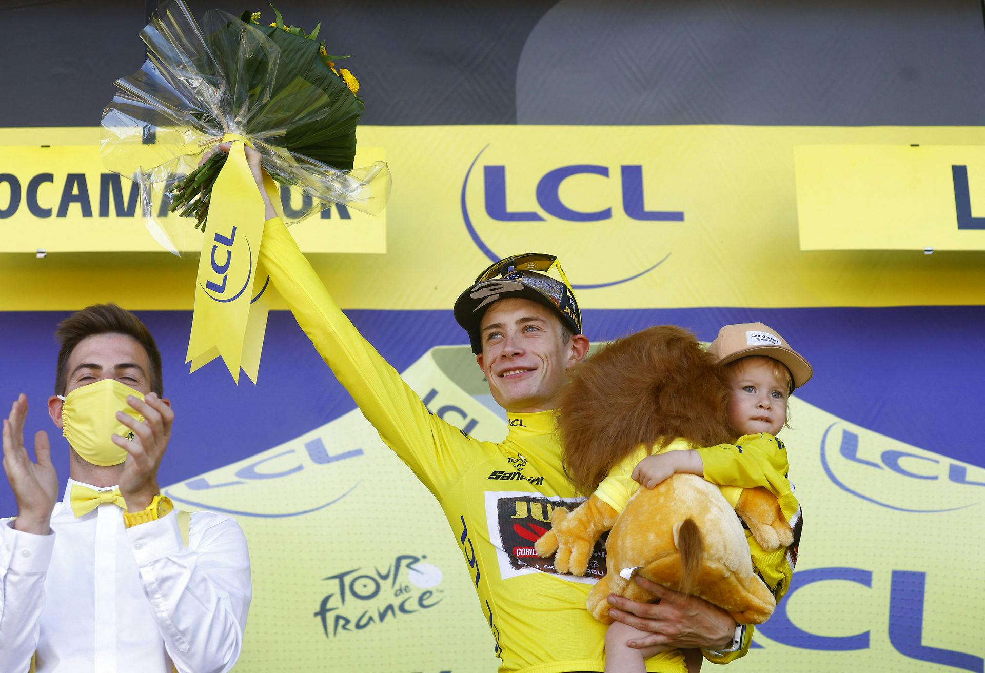 Jonas Vingegaard på podiet efter at have sikret sig den gule trøje på 20. etape. På armen har han sin lille datter Frida.
