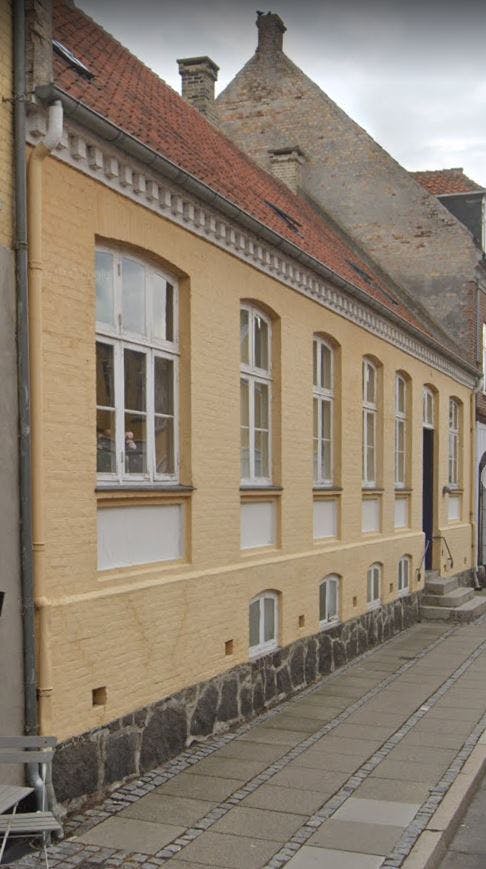 Signe Wennebergs byhus i Nysted, som nu kan købes. Bag huset ligger en stor blomsterhave.
