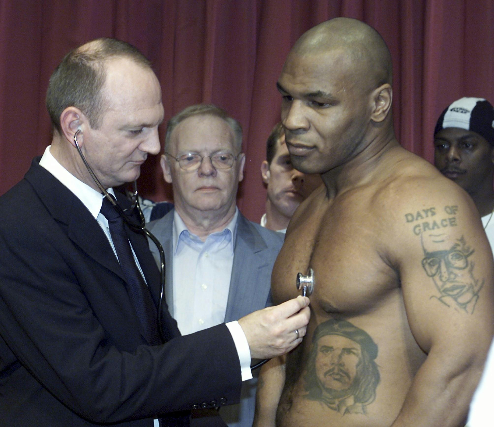 Den danske bokselæge Niels Jørn Lindgaard Kjeldsen undersøger bokser Mike Tyson forud for boksekampen mod Brian Nielsen i 2001. Promotor Mogens Palle ser til fra baggrunden.
