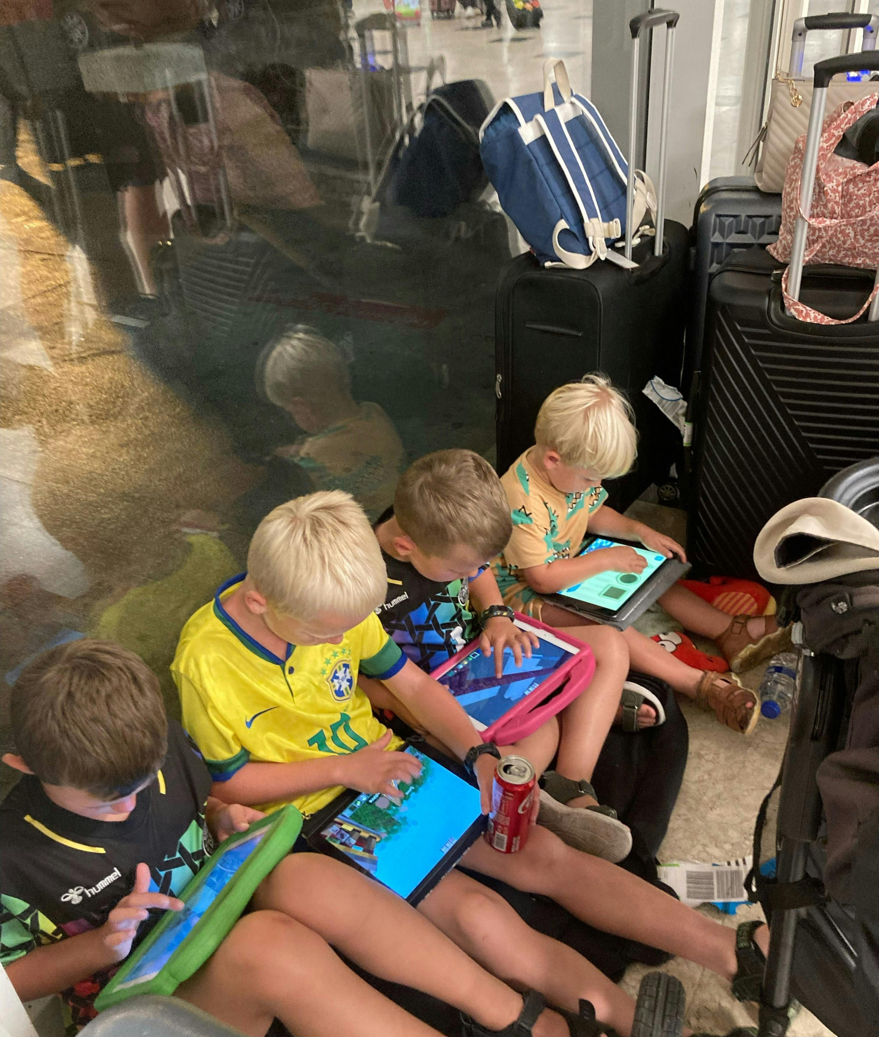 De fire børn har gudskelov kunne få tiden til at gå med lidt Ipad-tid, når familierne har været strandet i hotellobbyen.&nbsp;
