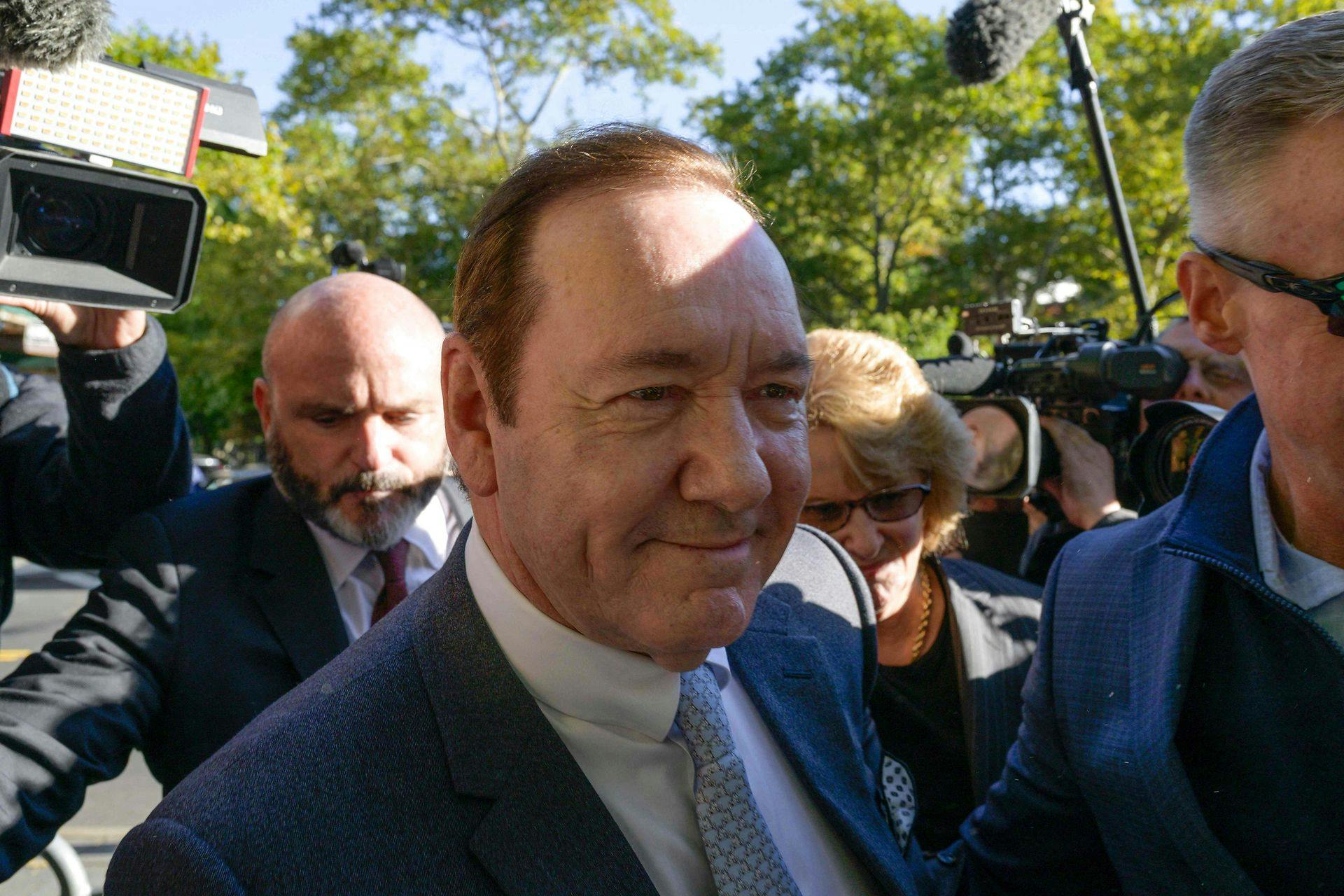 Kevin Spacey ankommer smilende til retten.