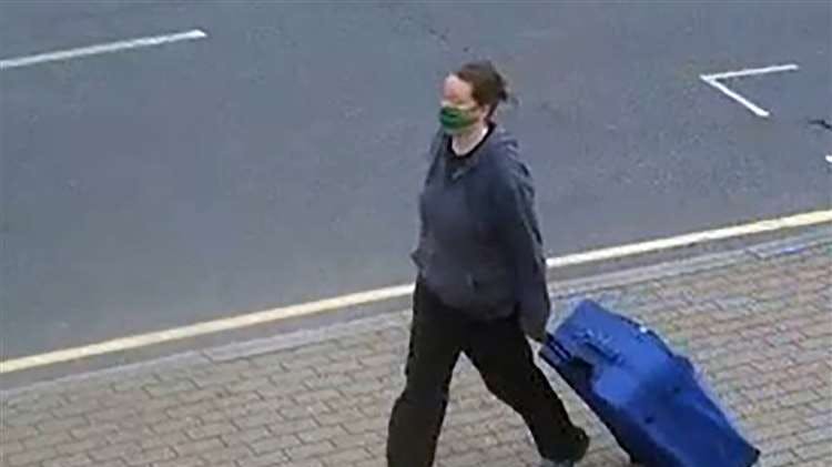 Her går 38-årige Jenna Mitchell på gaden med en stor, blå kuffert, hvor 67-årige Mee Kuen Chong ifølge anklagemyndigheden ligger parteret.