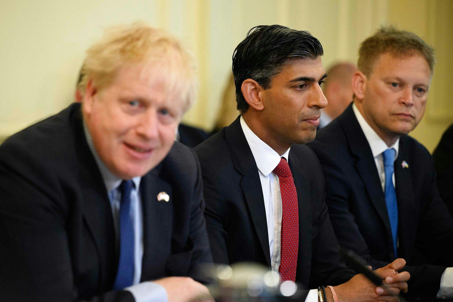 Manden i midten, Rishi Sunak, vil nu sidde for bordenden. Spørgsmålet er, om hans politiske fjende nummer 1, Boris Johnson (t.v.), vil lade ham få jobbet som premierminister.