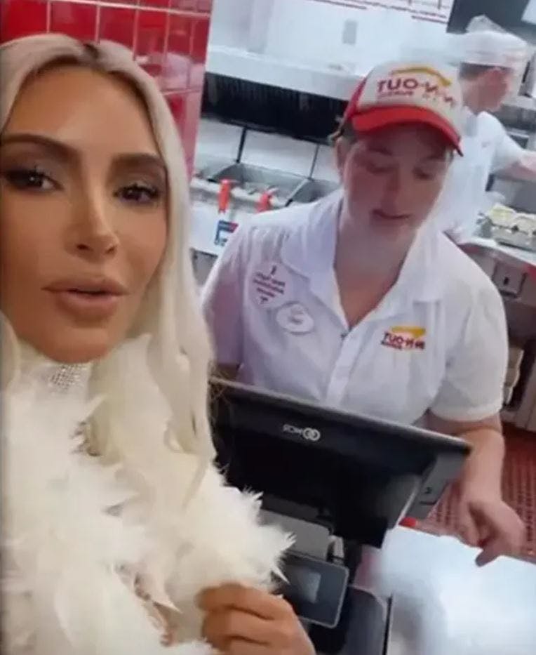 Kim Kardashian måtte lige klæde sig i en fjerboa, før hun trådte ind på fastfoodrestauranten.
