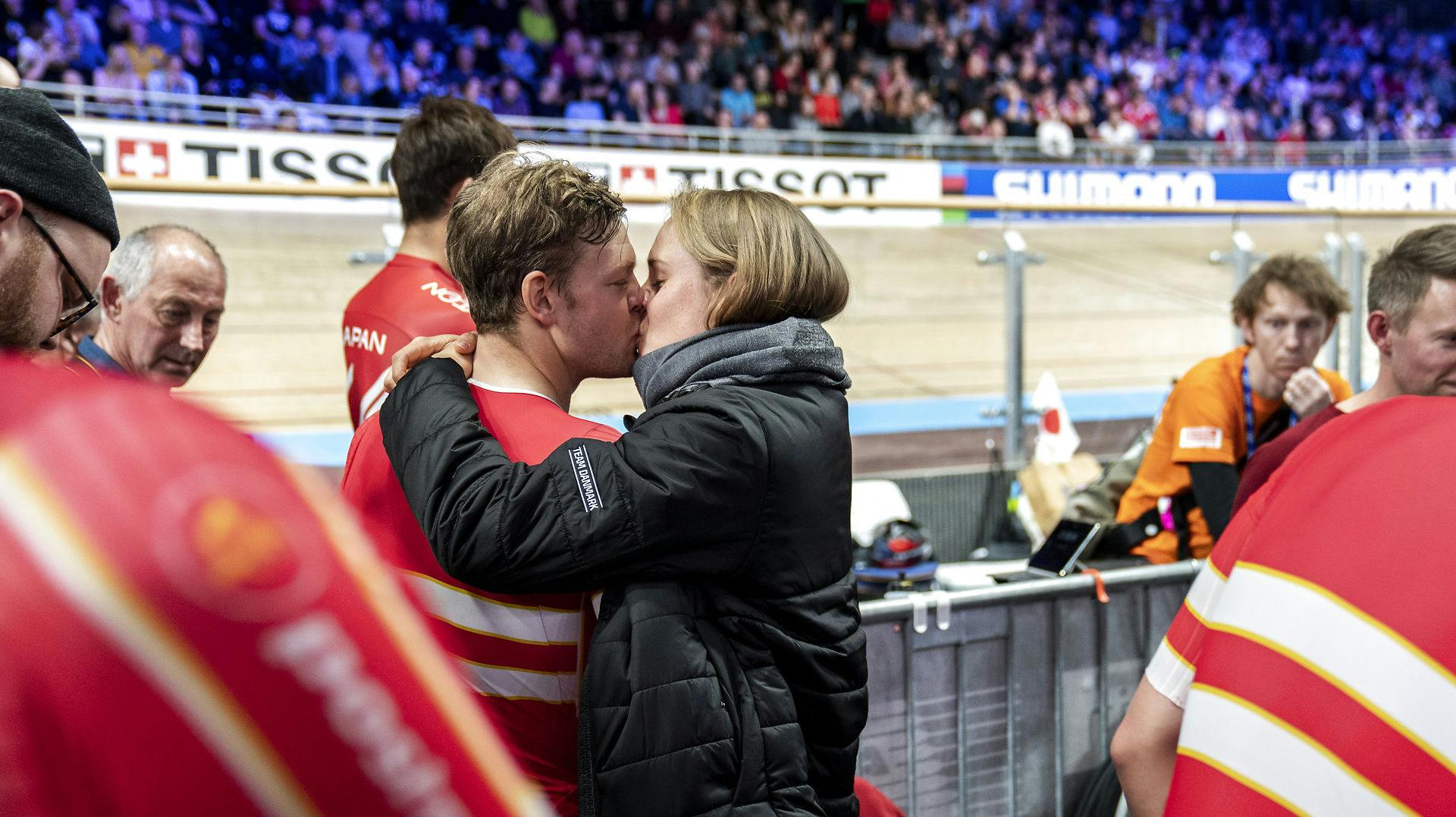 Lasse Norman og Julie Leth et i et stort kys efter, at Lasse Norman var med på holdet, der satte verdensrekord i 4000 meter holdforfølgelsesløb ved VM i Berlin 2021.