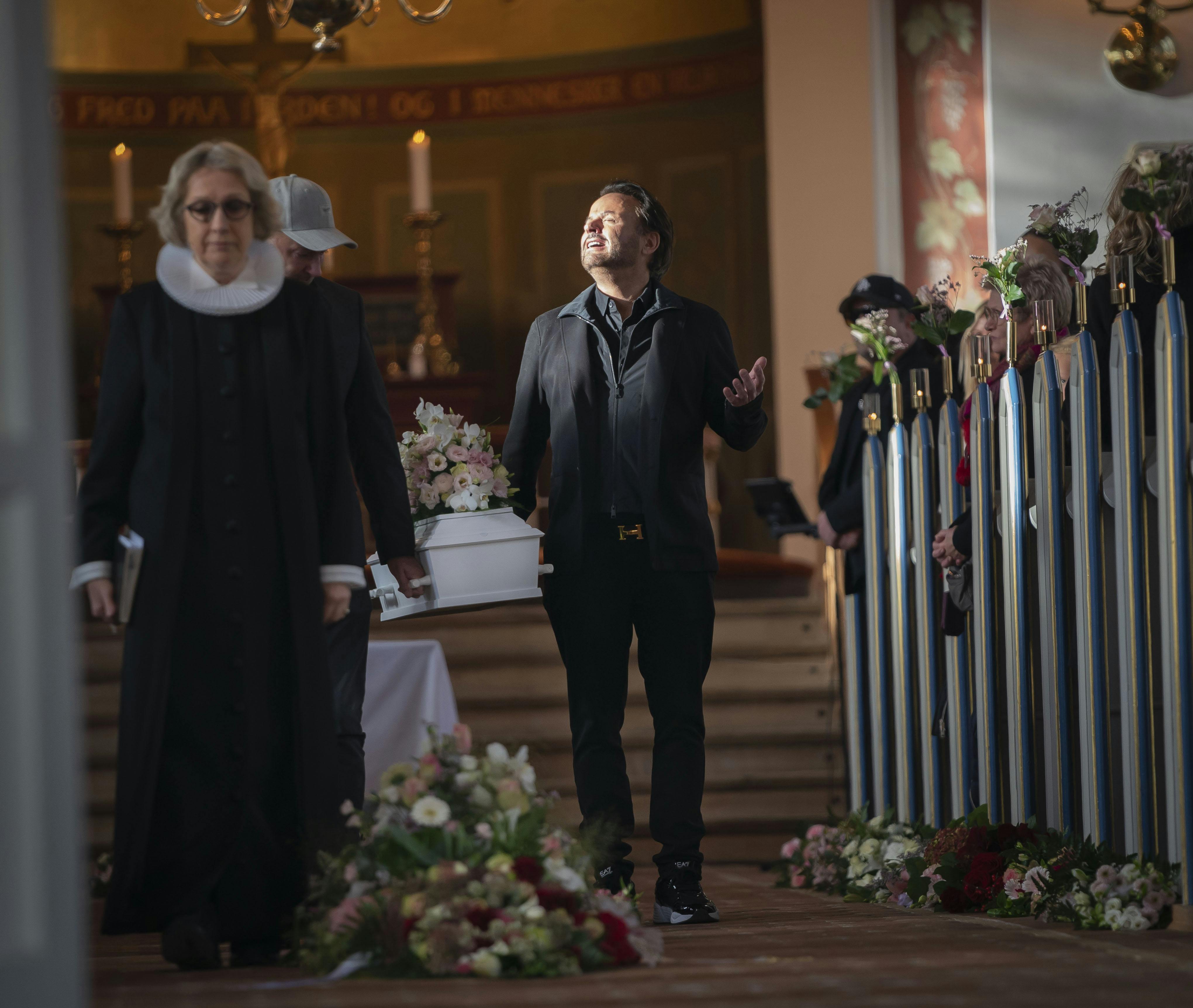 Mens han bar lille Naomis kiste ud af kirken hen mod slutningen af den rørende ceremoni, lod den sorgbetyngede Dennis Knudsen solen ramme sit ansigt. 