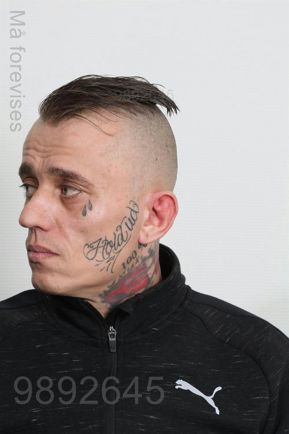 Chris Funder Buch har flere synlige tatoveringer i ansigtet og på halsen. På den ene kind står der "hold ud."