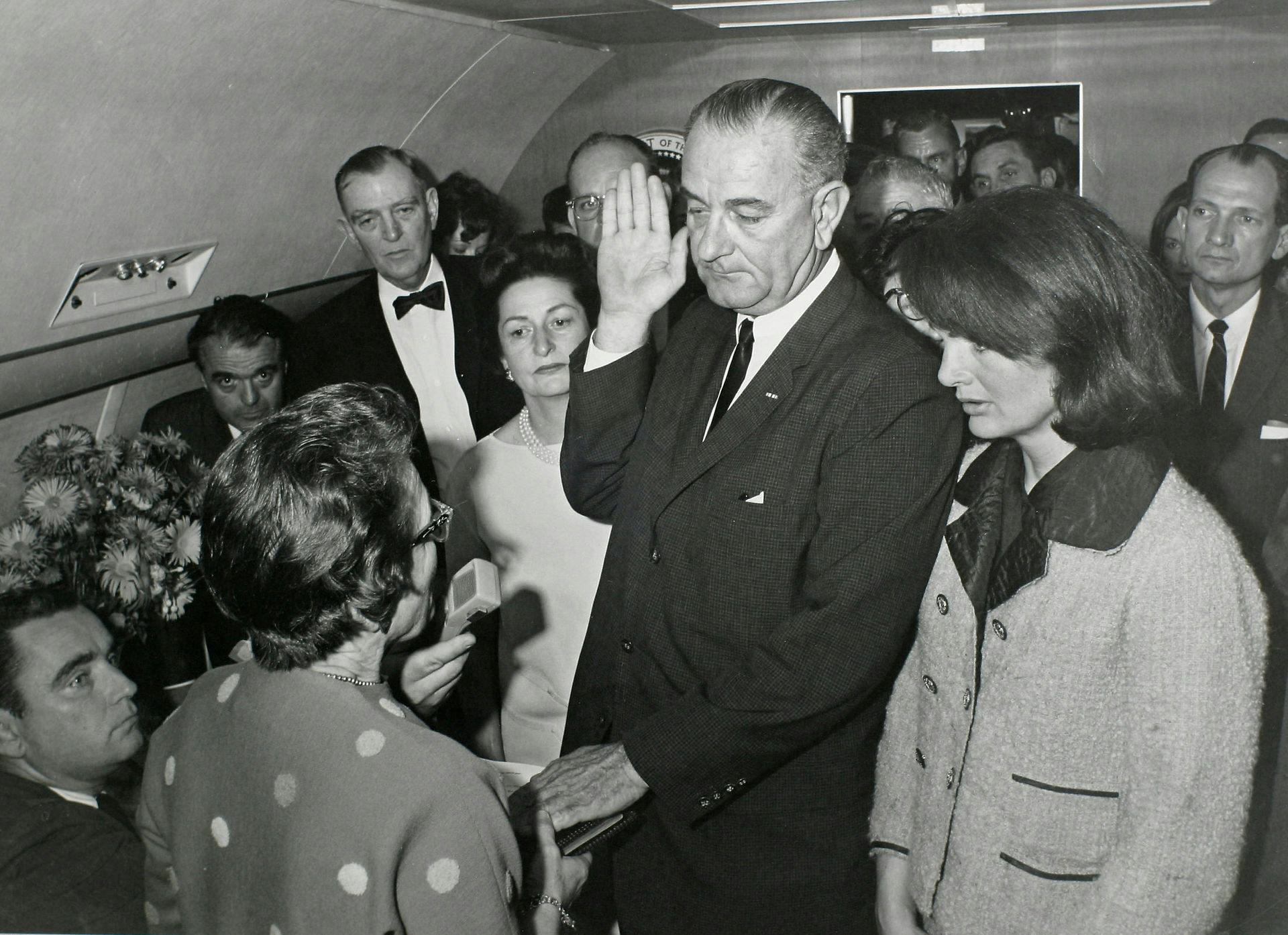 Lyndon B. Johnson ombord Air Force One. Jackie bærer stadig den blodstængte Chanel-frakke.&nbsp;
