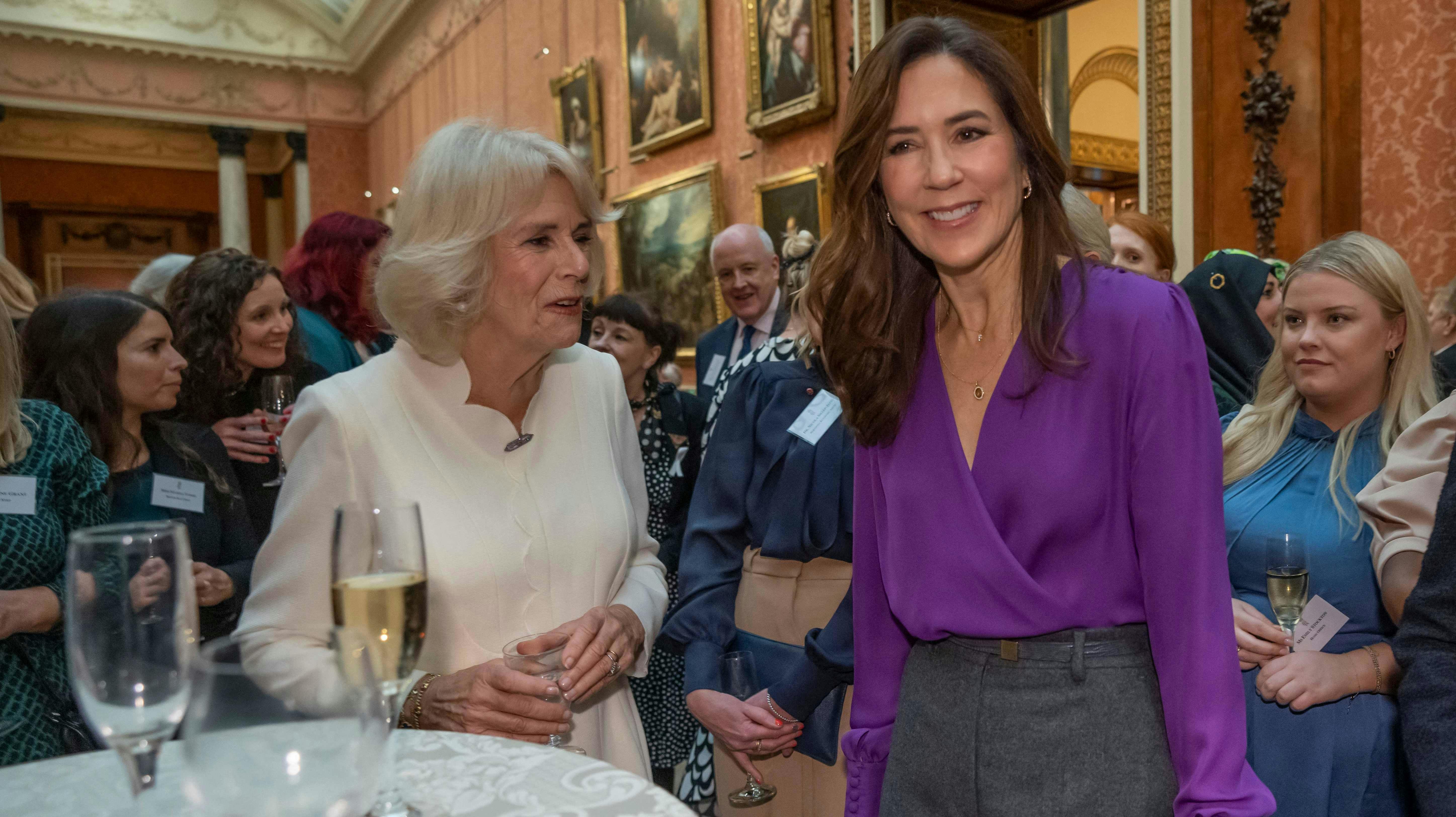 Kronprinsesse Mary får sig her en hyggelig snak med dronning Camilla, der har inviteret til reception på Buckingham Palace. 