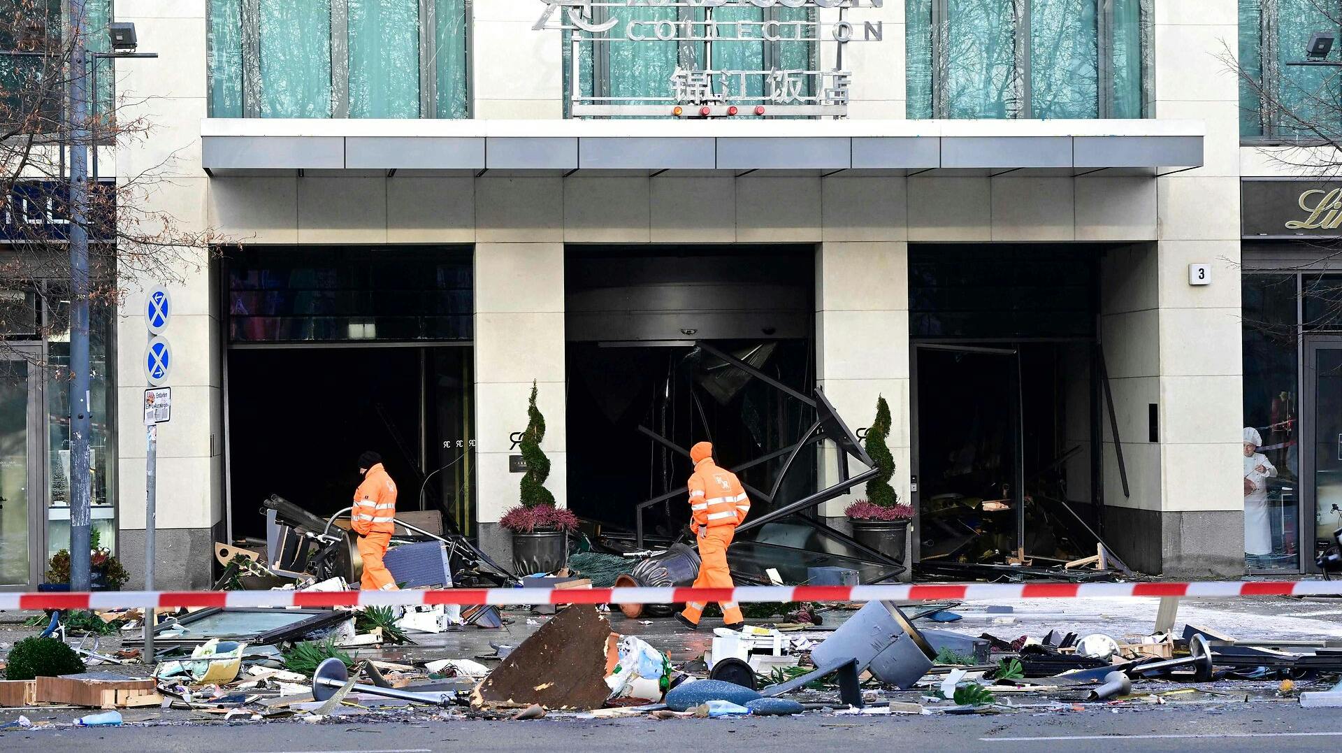 Et oprydsningshold prøver at danne sig et overblik ude foran hotellet i Berlin, hvor det kæmpe akvarie gik i stykker.