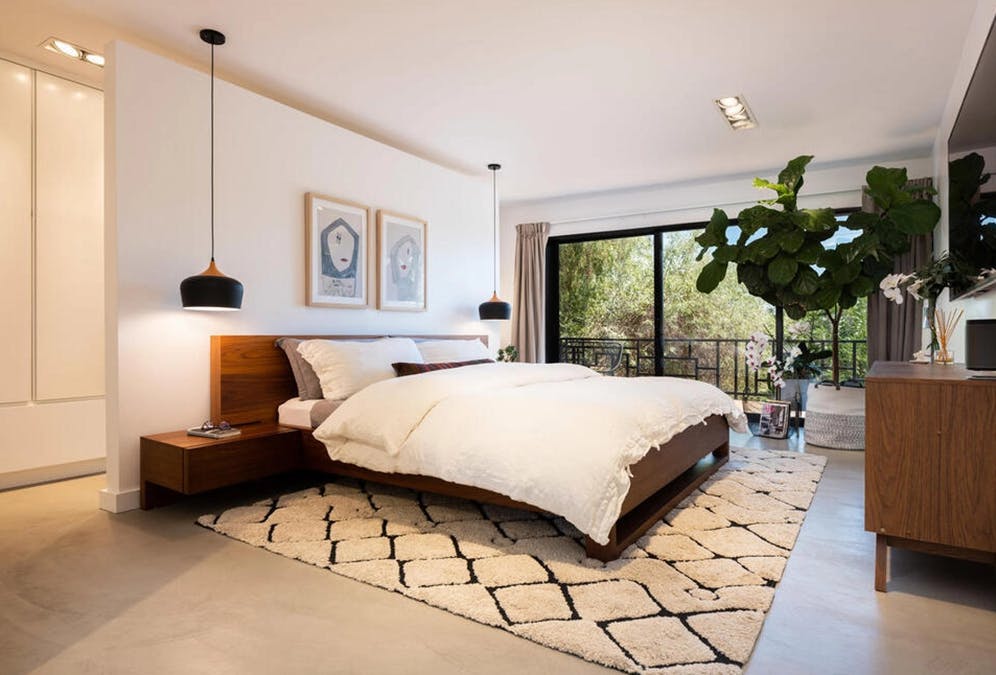 Væggen bag sengen gemmer på et walk in-closet. 