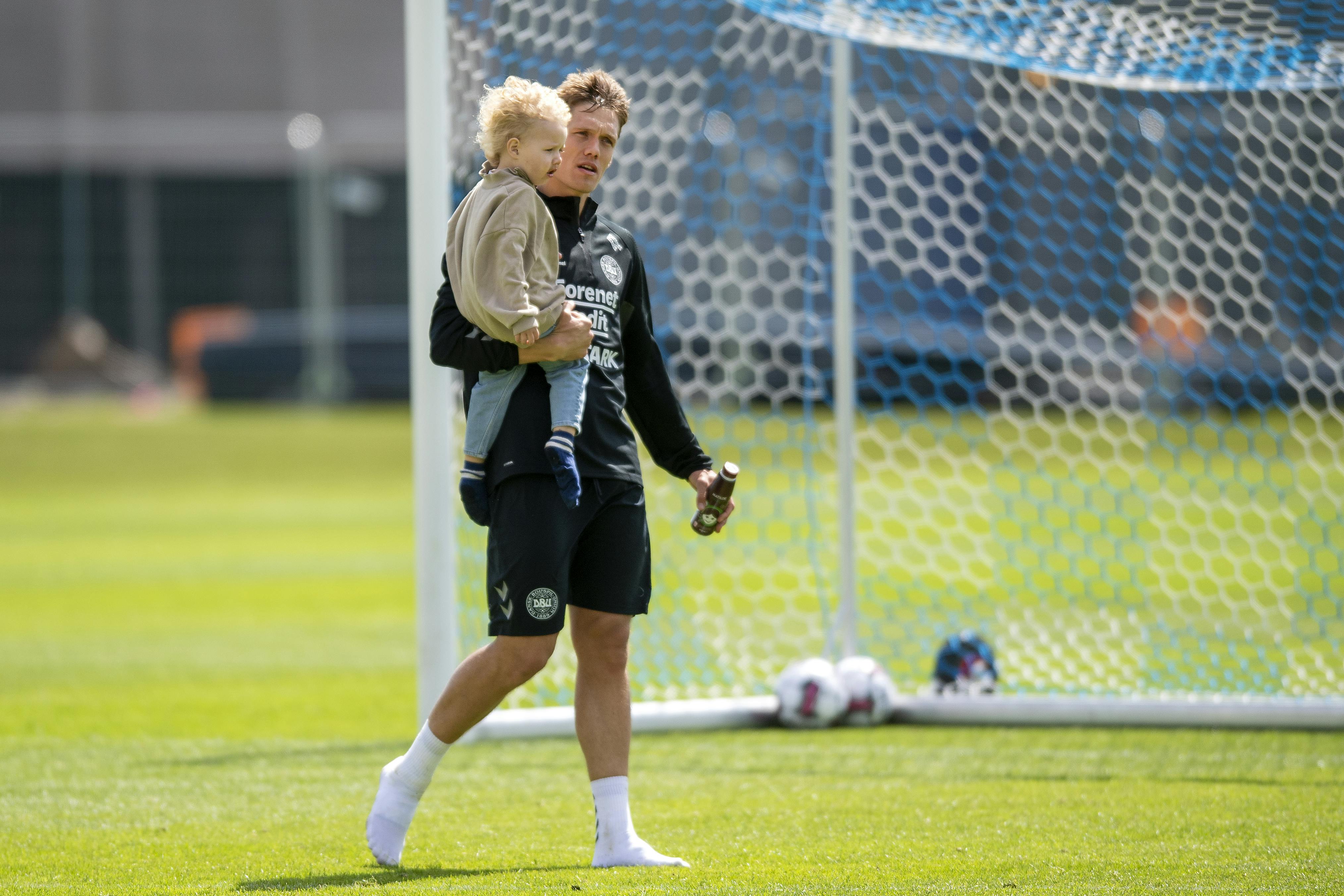 Jannik Vestergaard med sin søn på armen til en landsholdssamling.