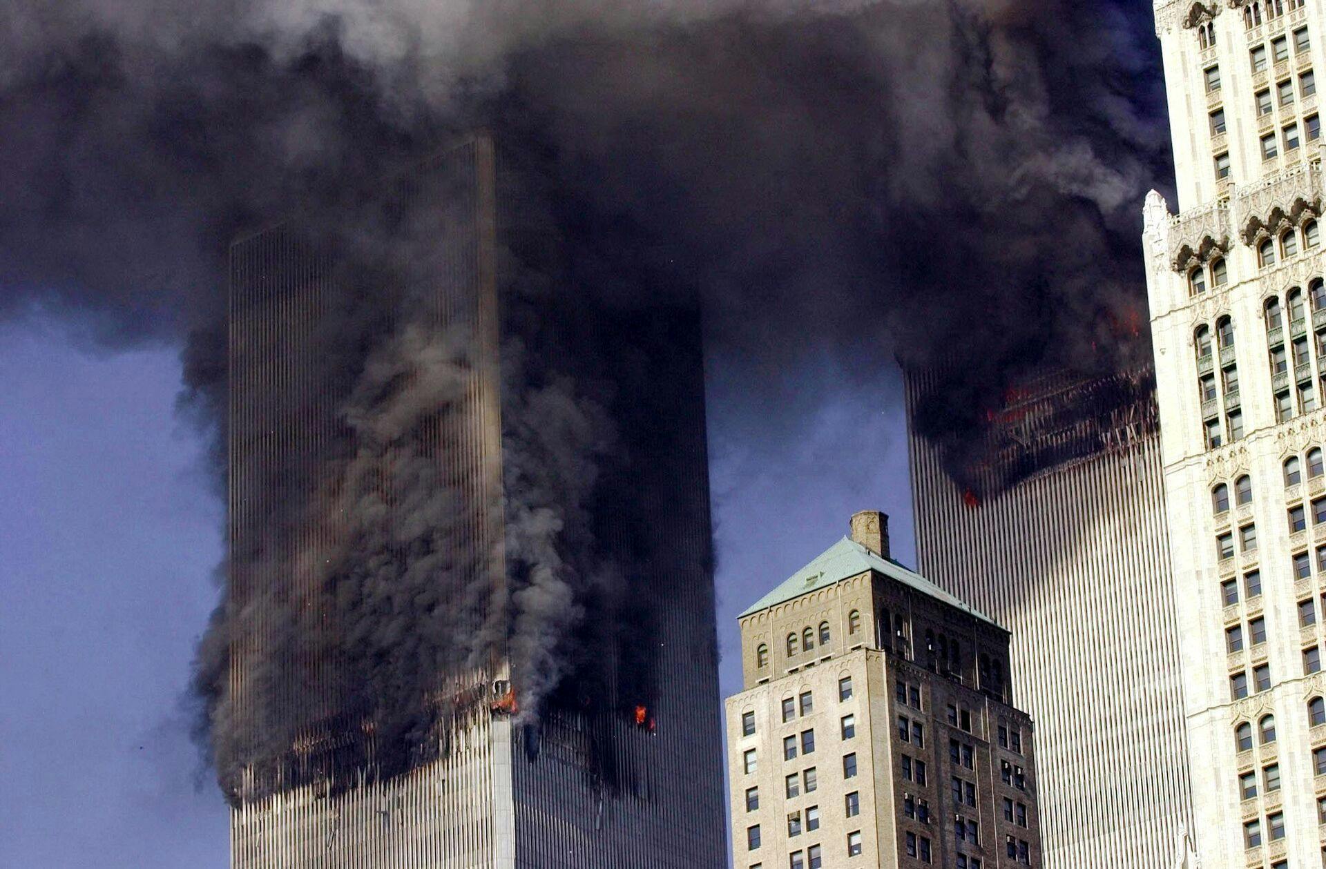 De to fly er fløjet ind i hvert sit tvillingetårn og sort røg vælter ud fra bygningerne.
