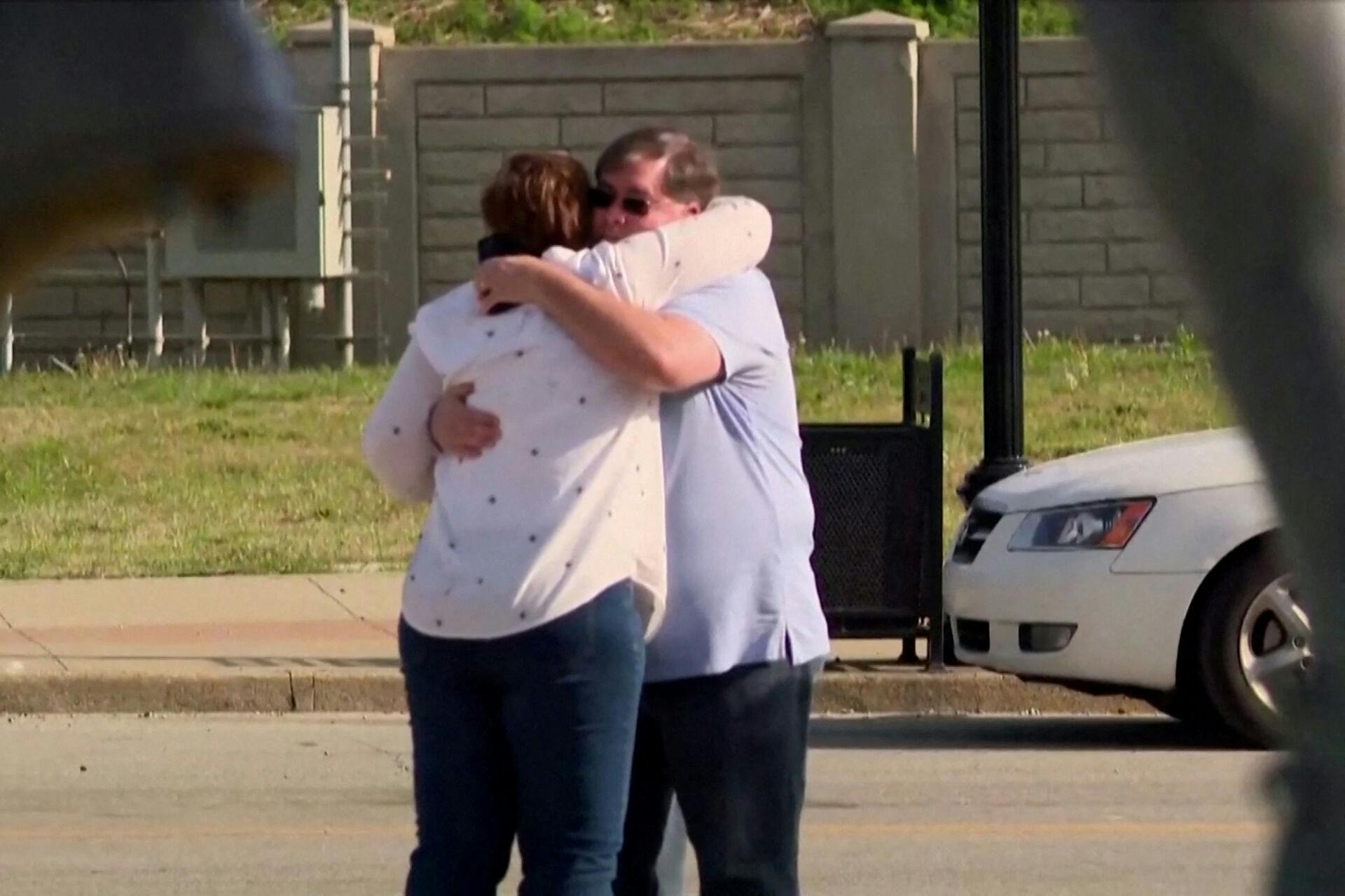 Folk trøster hinanden efter skyderiet, der fandt sted i en bank i Kentucky.