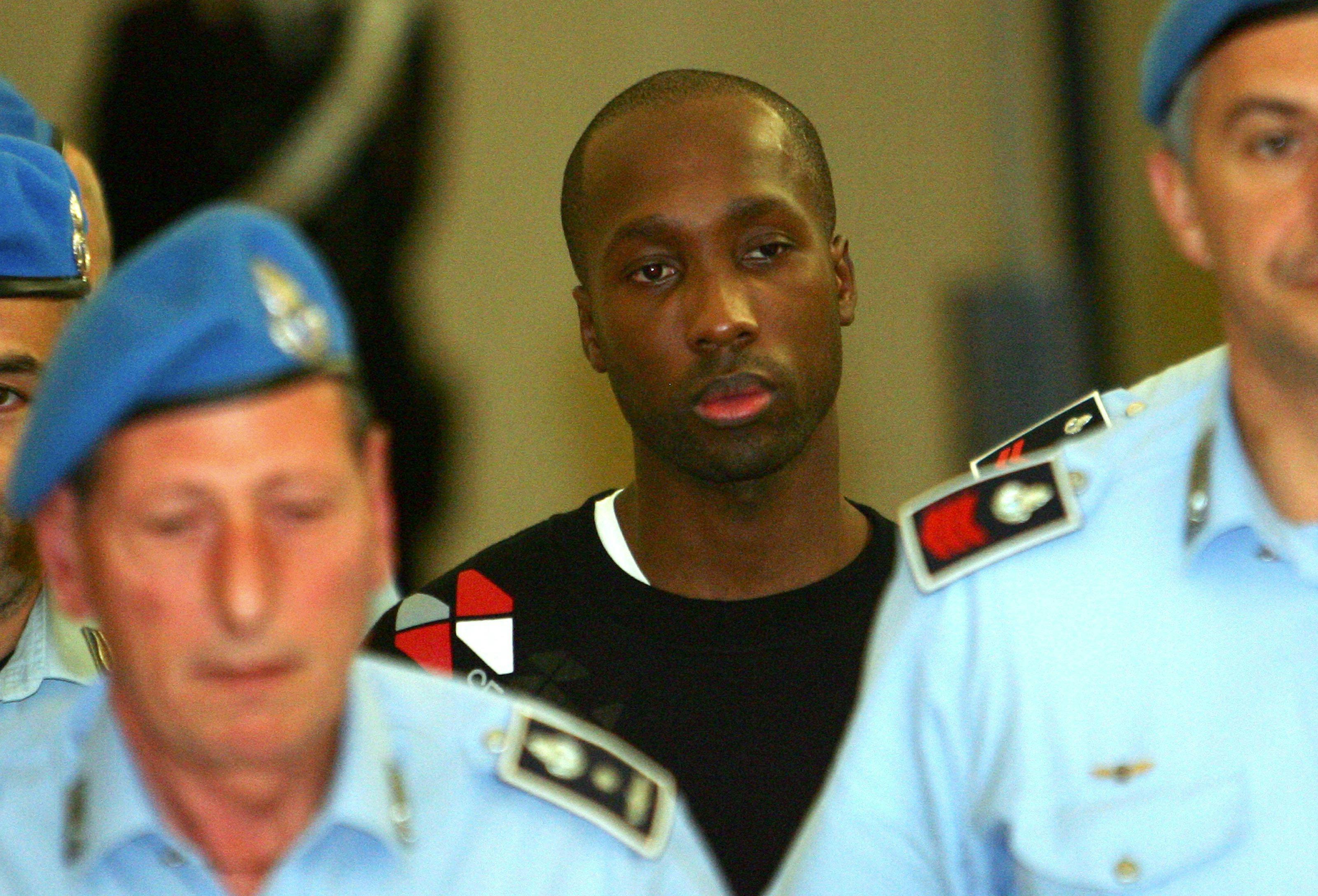Rudy Guede (i midten), i dag 36 år, blev pågrebet i Tyskland, hvor han var flygtet til under falsk navn. Han fik 30 års fængsel, der dog senere blev omstødt til 16 år på grund af hans hårde barndom.

