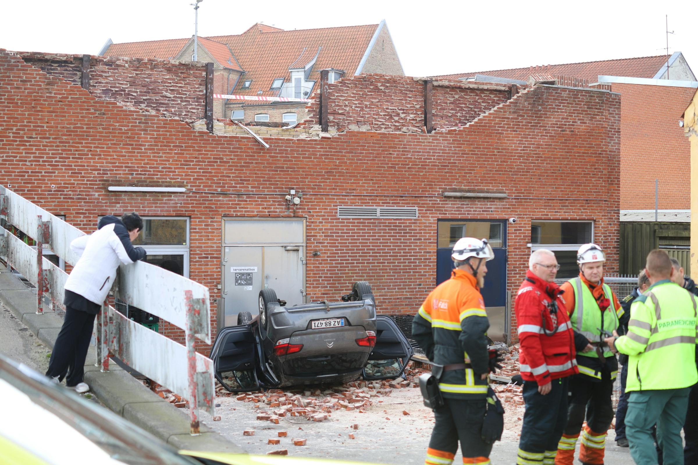 En bil faldt fire meter, efter føreren kørte igennem en mur i et parkeringshus.