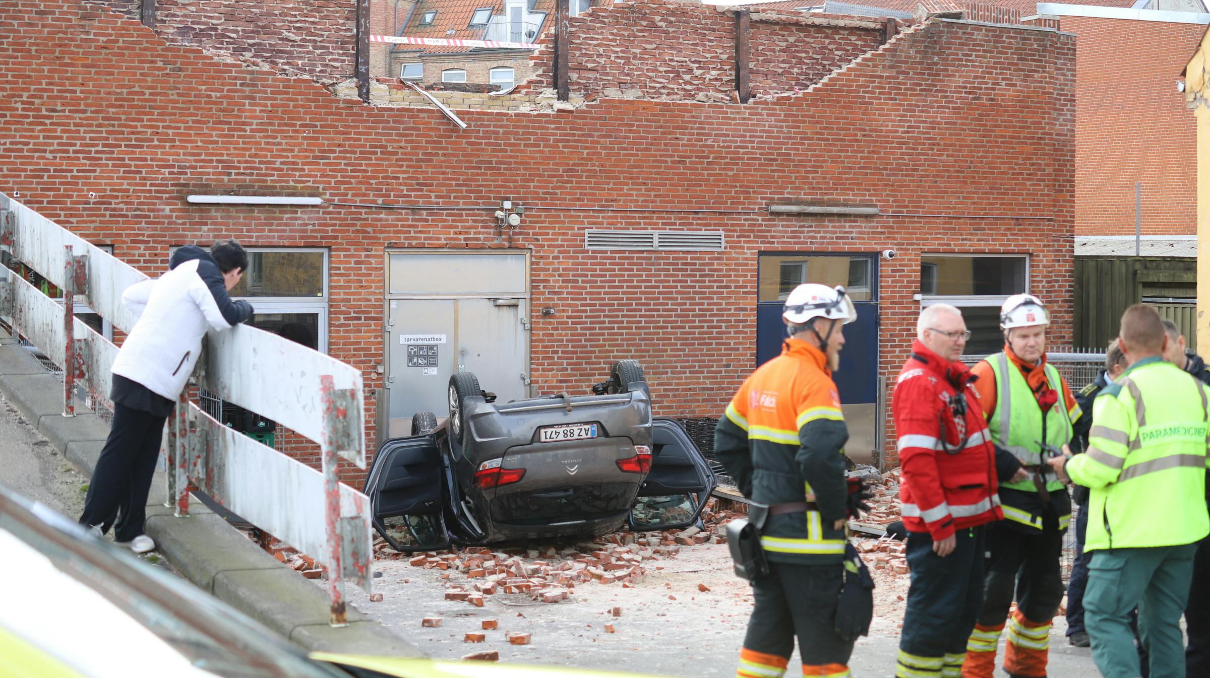 En bil faldt fire meter, efter føreren kørte igennem en mur i et parkeringshus.