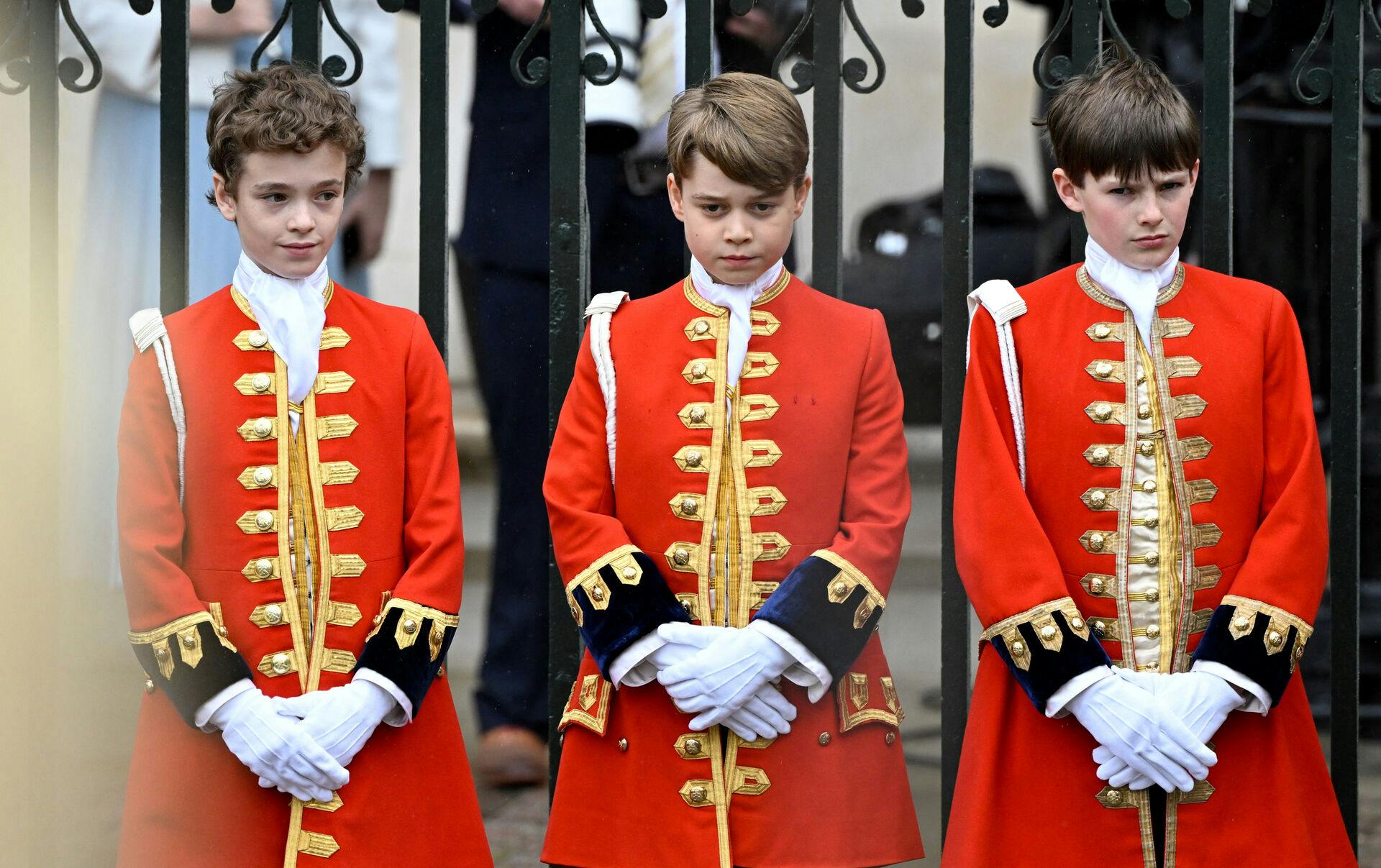 Prins George (i midten) er en del af det hold, der bar kong Charles' kåbe ind i Westminster Abbey.
