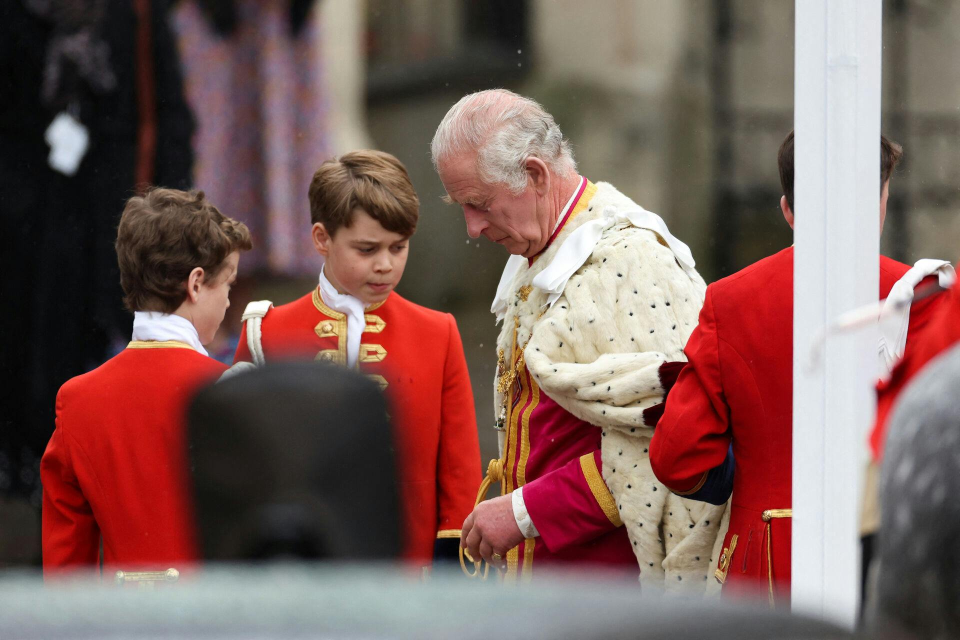 Prins George (i midten, red.) hjælper sin farfar ind i kirken.