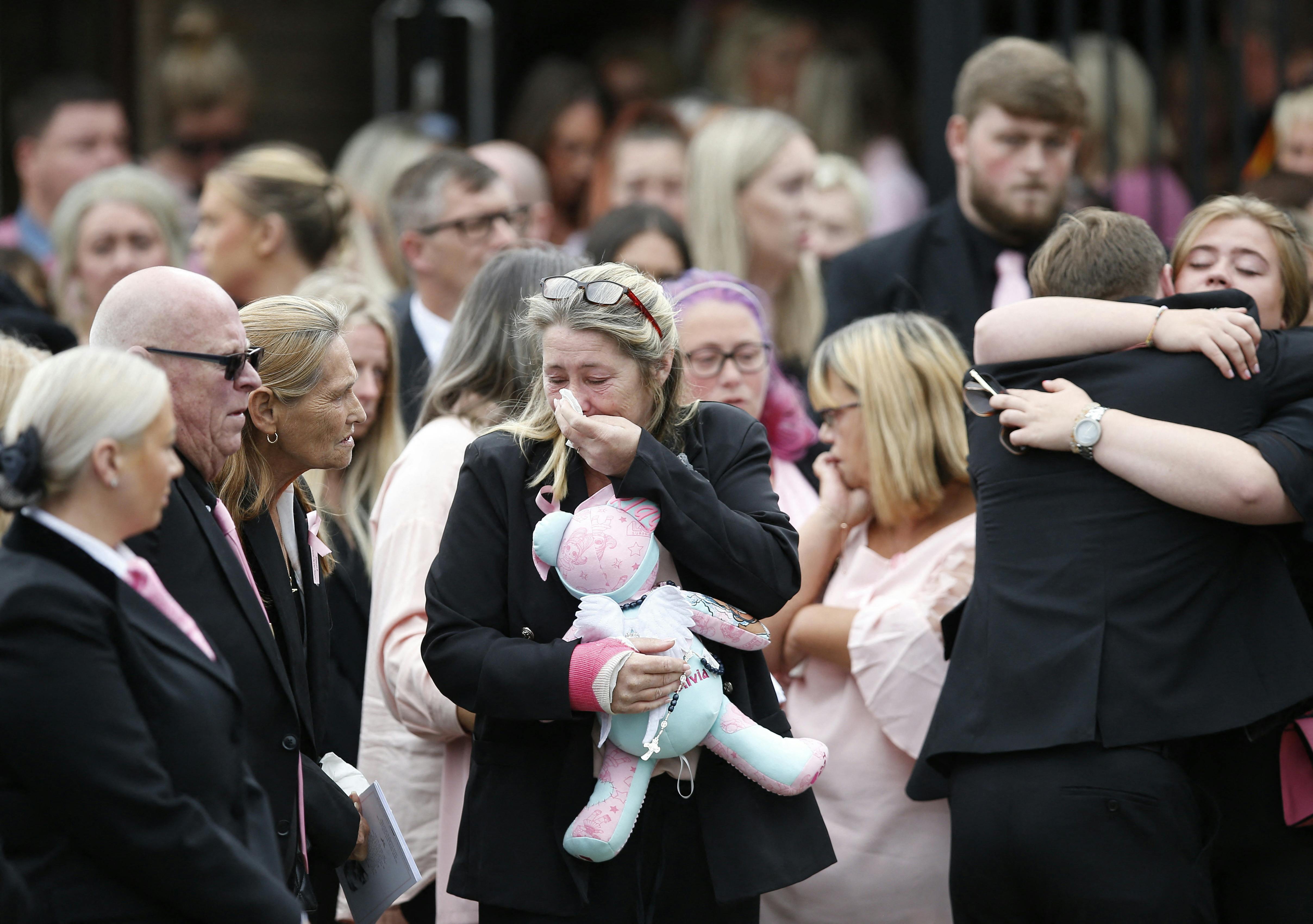 Olivias mor, Cheryl Korbel, brød sammen, mens hun knugede datterens bamse under bisættelsen. Hendes højre arm var i gips, efter hun også blev ramt af skud.
