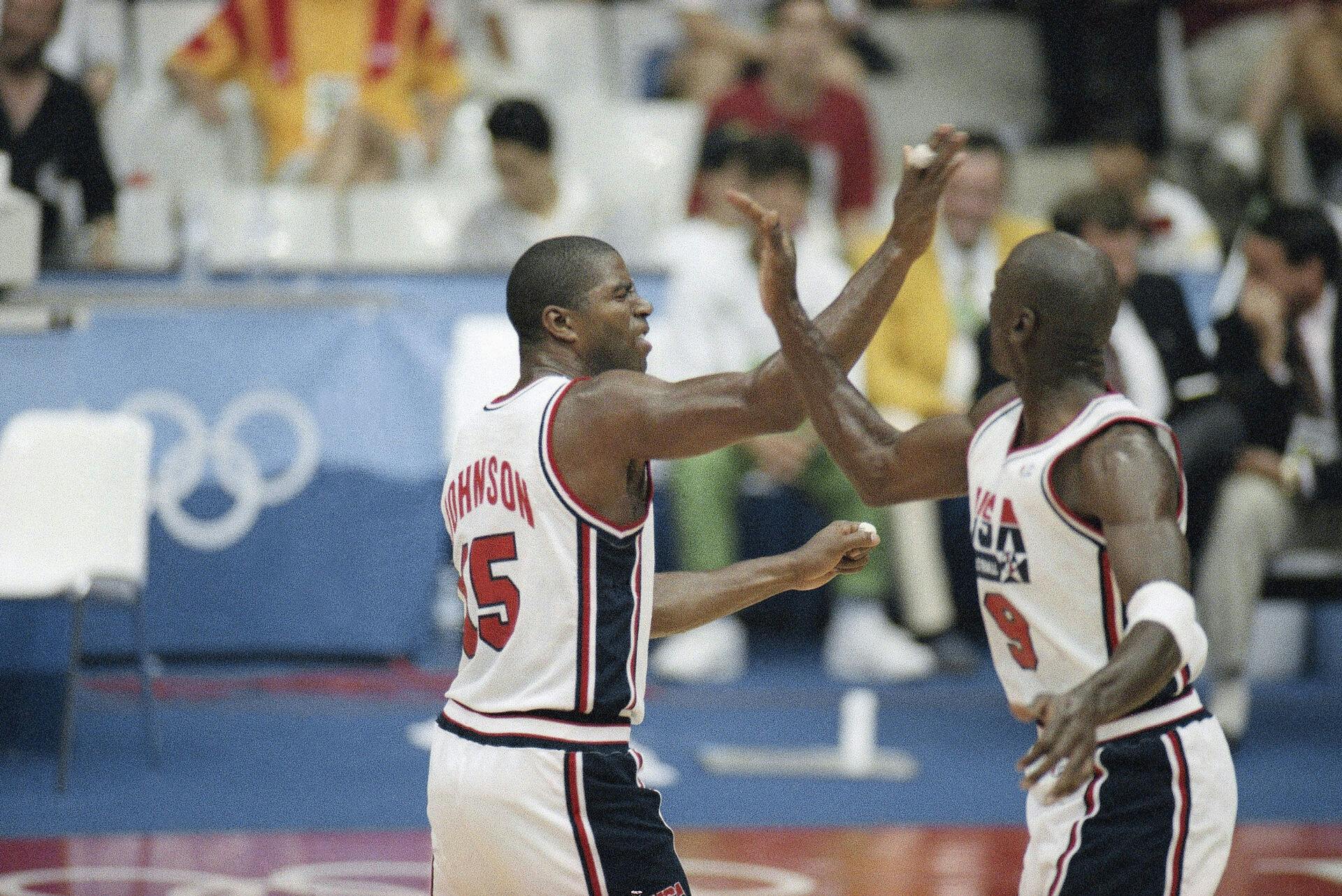 Magic Johnson og Michael Jordan (til højre) jubler i forbindelse med USA's første kamp ved OL i 1992 mod Angola. En trøje fra semifinalen mod Litauen er torsdag blevet solgt for 20 millioner kroner.&nbsp;
