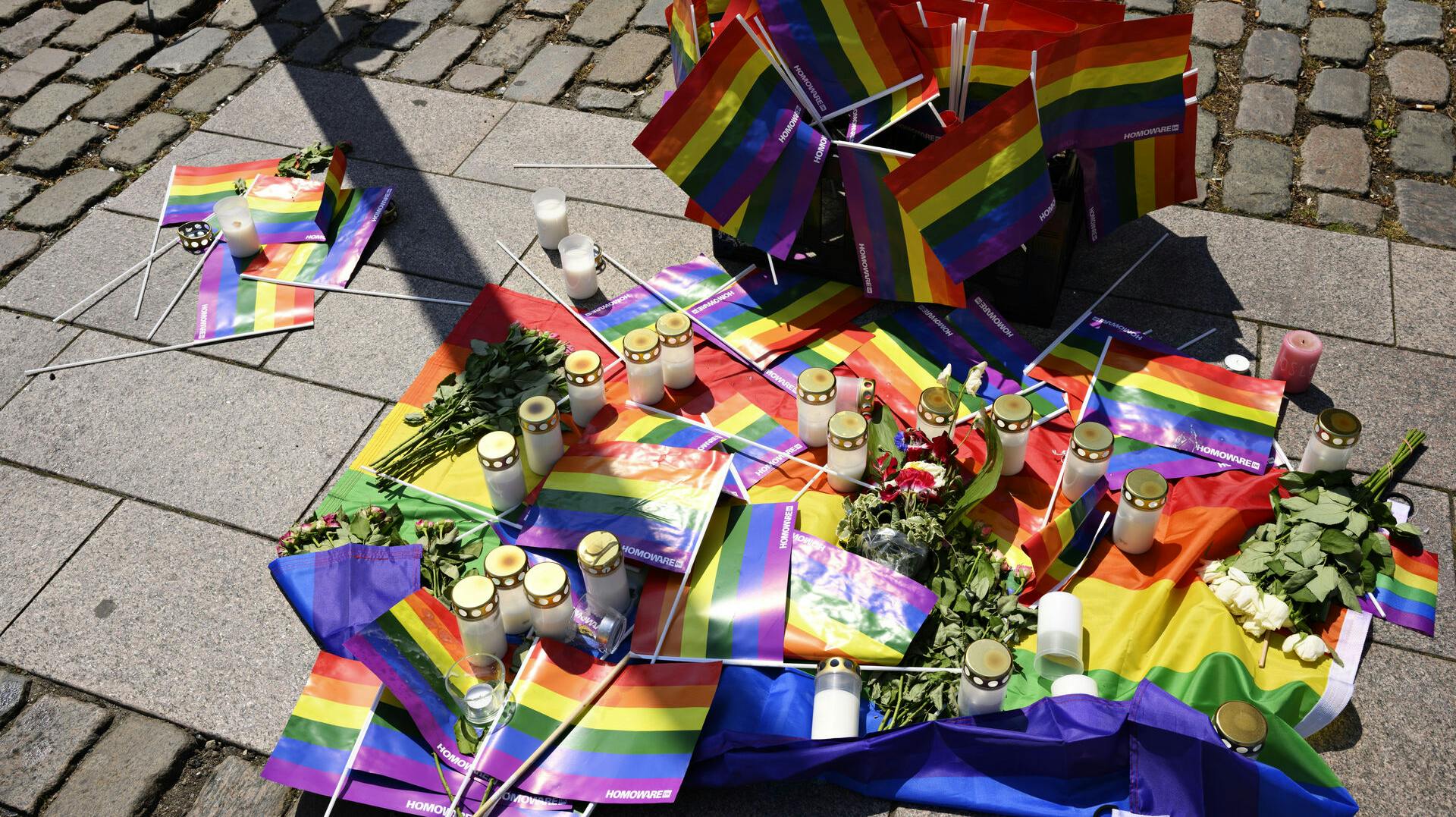 Der blev lagt regnbueflag, blomster og tændt lys på Regnbuepladsen ved Rådhuspladsen i København for at mindes ofrene for skyderiet i Oslo, søndag den 26. juni 2022.