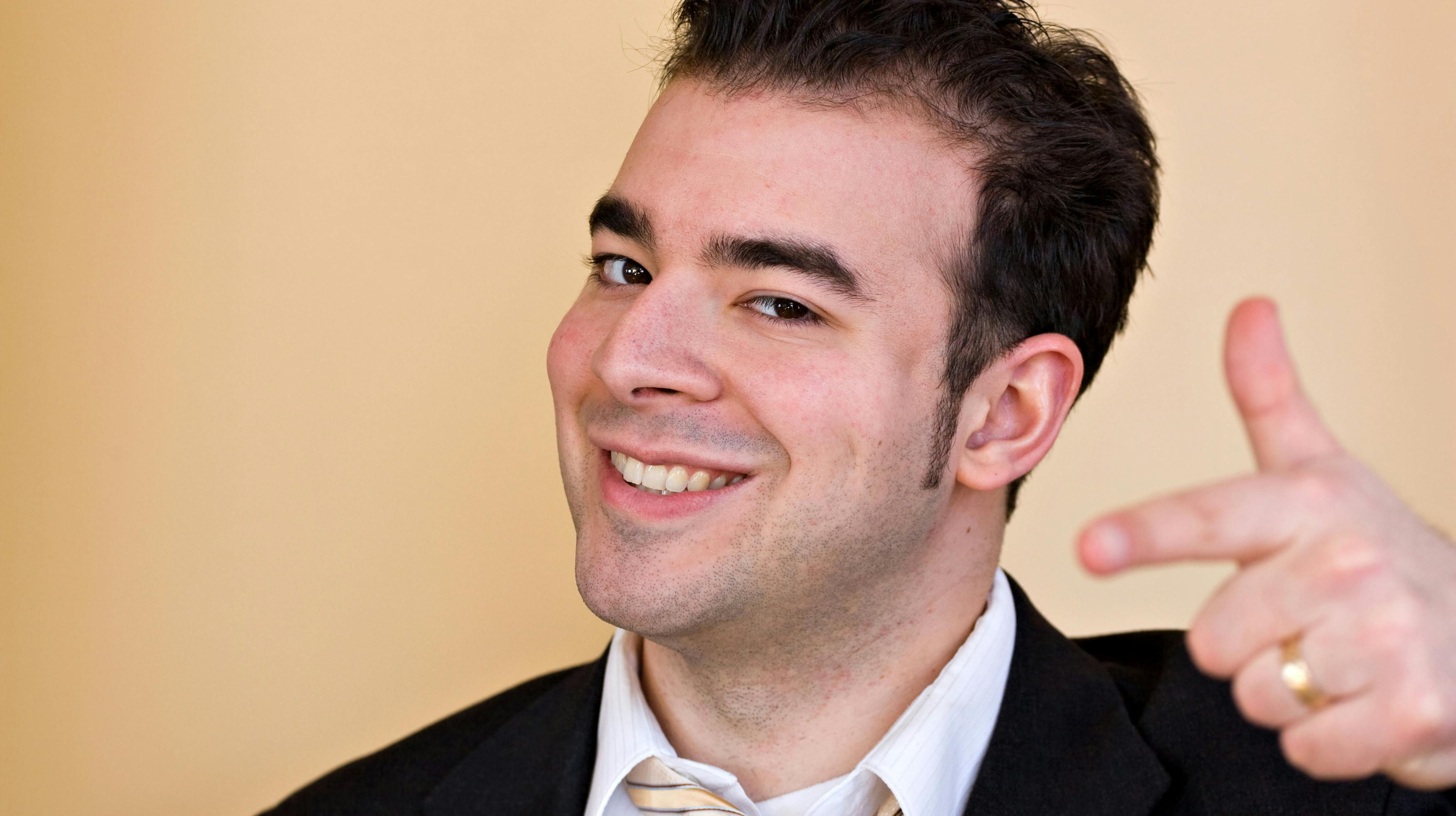 A goofy smiling business man pointing and trying to act like he is a cool guy.  Shallow depth of field with focus on the face.