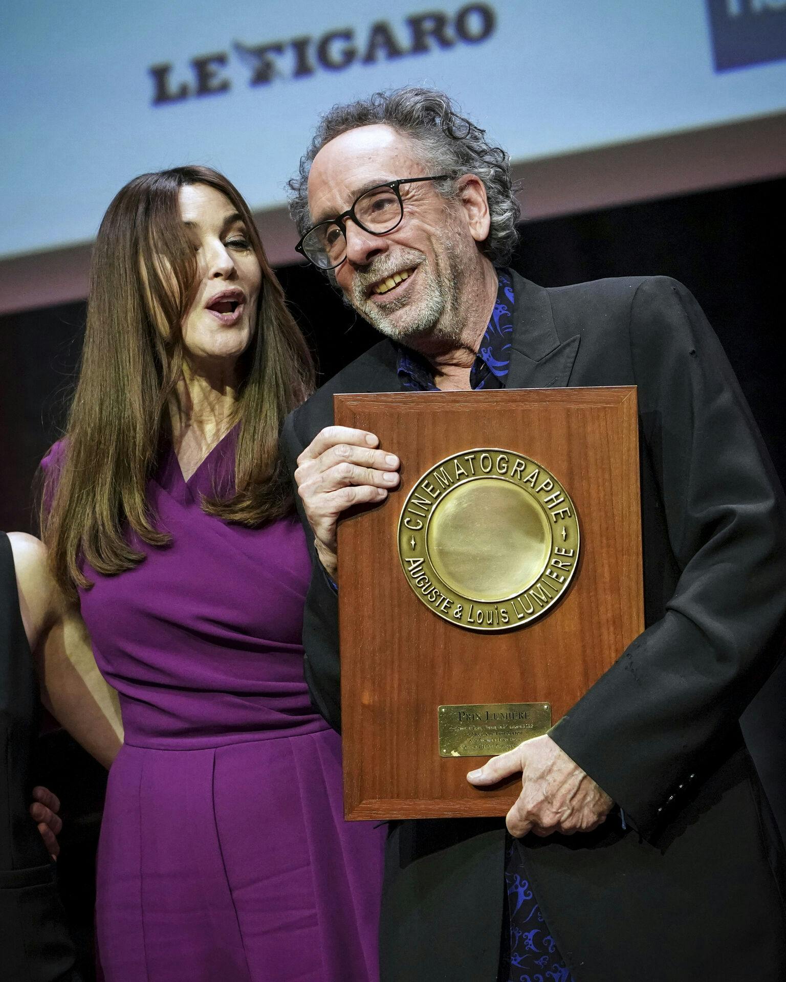 Italian actress Monica Bellucci speaks to US Director Tim Burton as he holds his award during the Lumiere Award ceremony of the 14th Lumiere Festival in Lyon, central France, Friday, Oct. 21, 2022. (AP Photo/Laurent Cipriani)