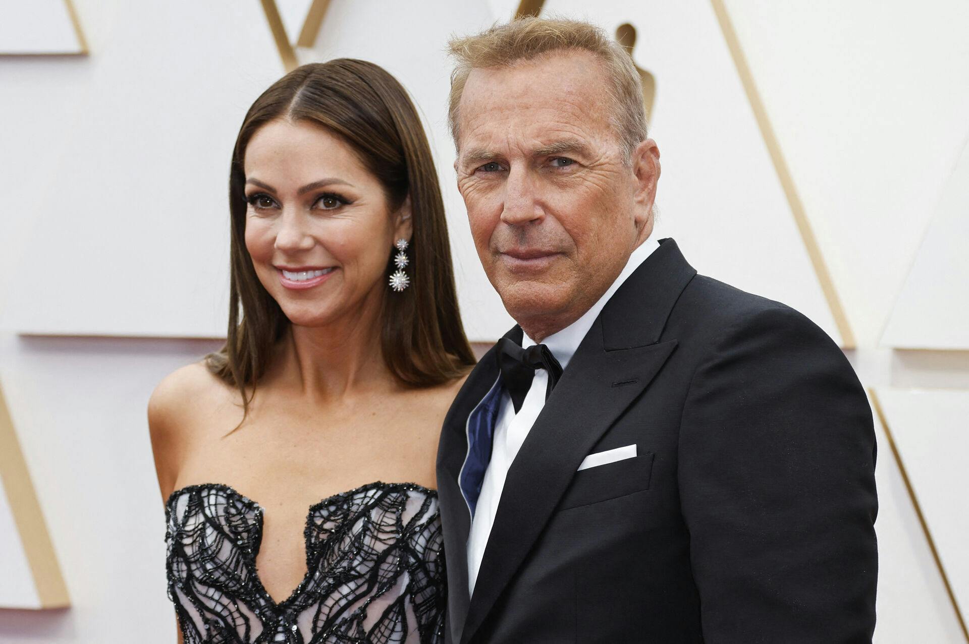 Kevin Costner and wife Christine Baumgartner pose on the red carpet during the Oscars arrivals at the 94th Academy Awards in Hollywood, Los Angeles, California, U.S., March 27, 2022. REUTERS/Eric Gaillard