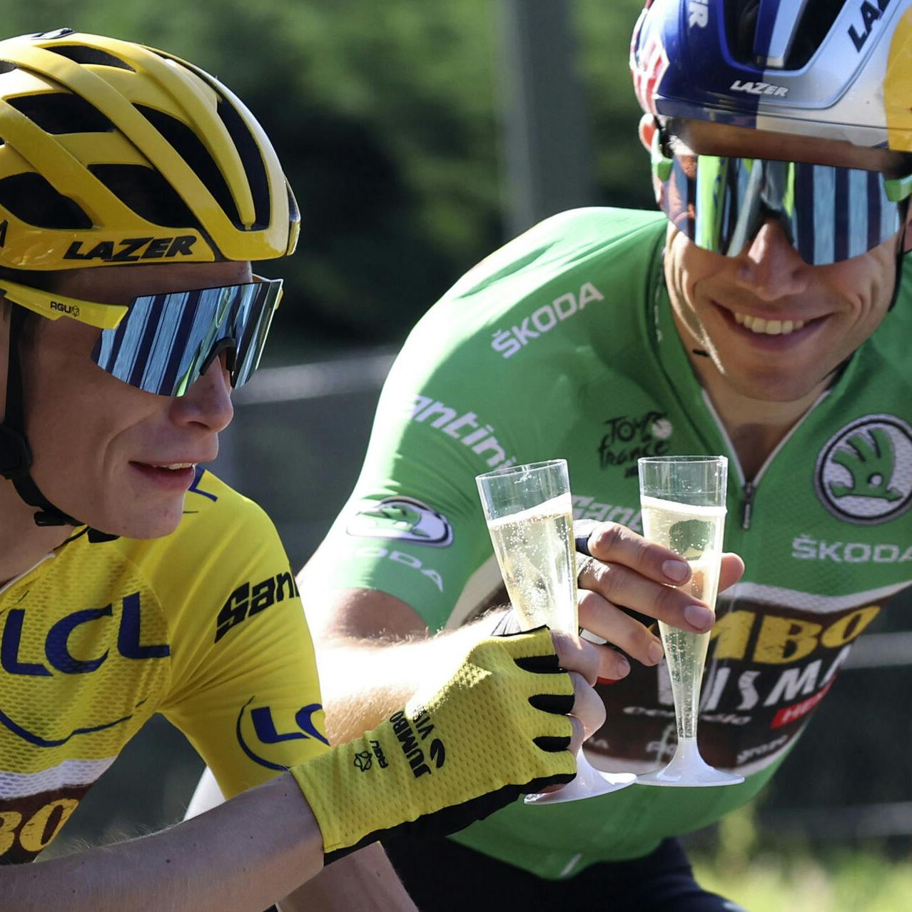 Denmark's Jonas Vingegaard, wearing the overall leader's yellow jersey, toasts champagne with teammates Belgium's Wout Van Aert, wearing the best sprinter's green jersey during the twenty-first stage of the Tour de France cycling race over 116 kilometers (72 miles) with start in Paris la Defense Arena and finish on the Champs Elysees in Paris, France, Sunday, July 24, 2022. (Thomas Samson/Pool Photo via AP)