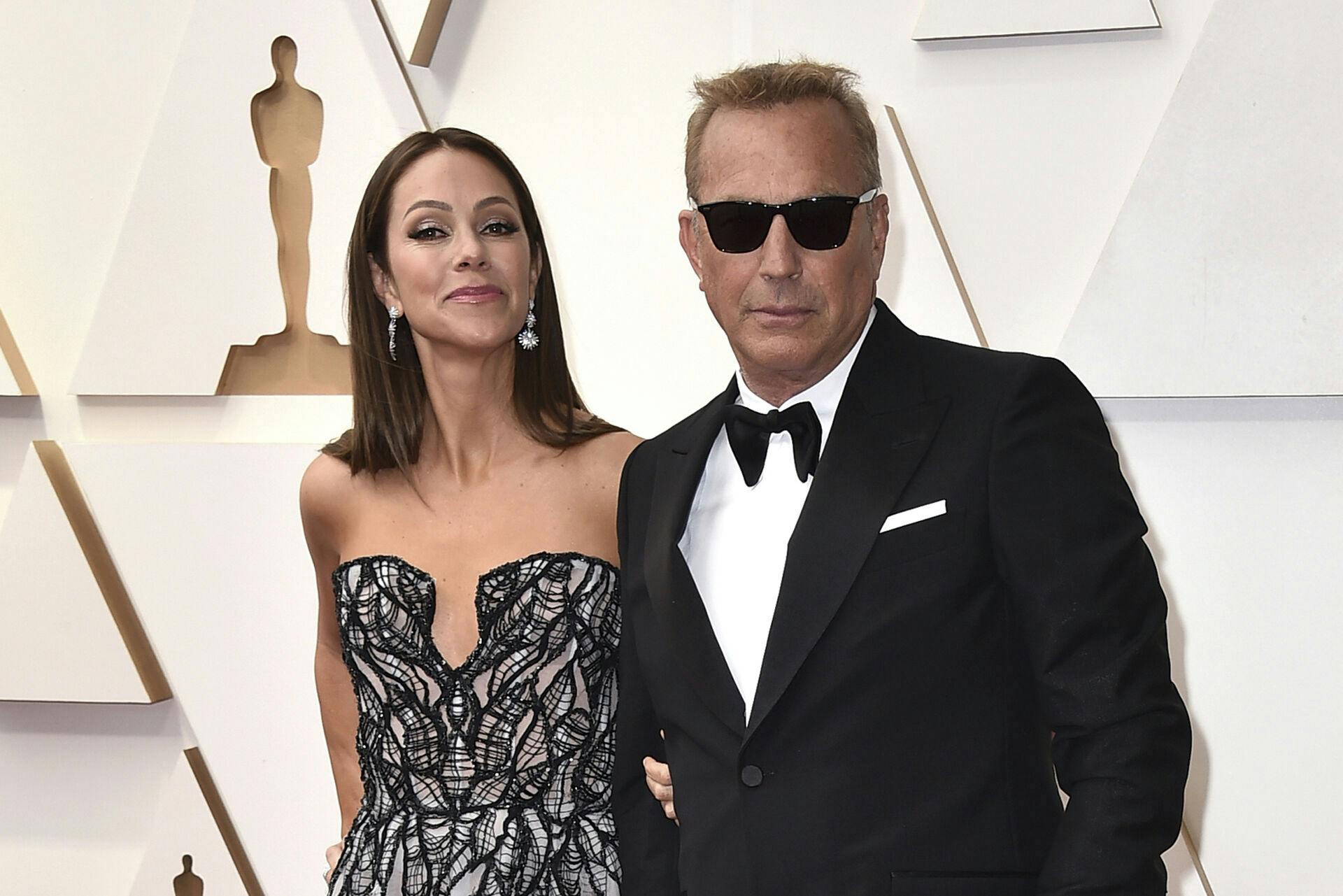 FILE - Christine Baumgartner, left, and Kevin Costner arrive at the Oscars, March 27, 2022, at the Dolby Theatre in Los Angeles. Costner and Baumgartner, his wife of nearly 19 years, are divorcing, a representative for the actor said Tuesday, May 2, 2023. (Photo by Jordan Strauss/Invision/AP, File)