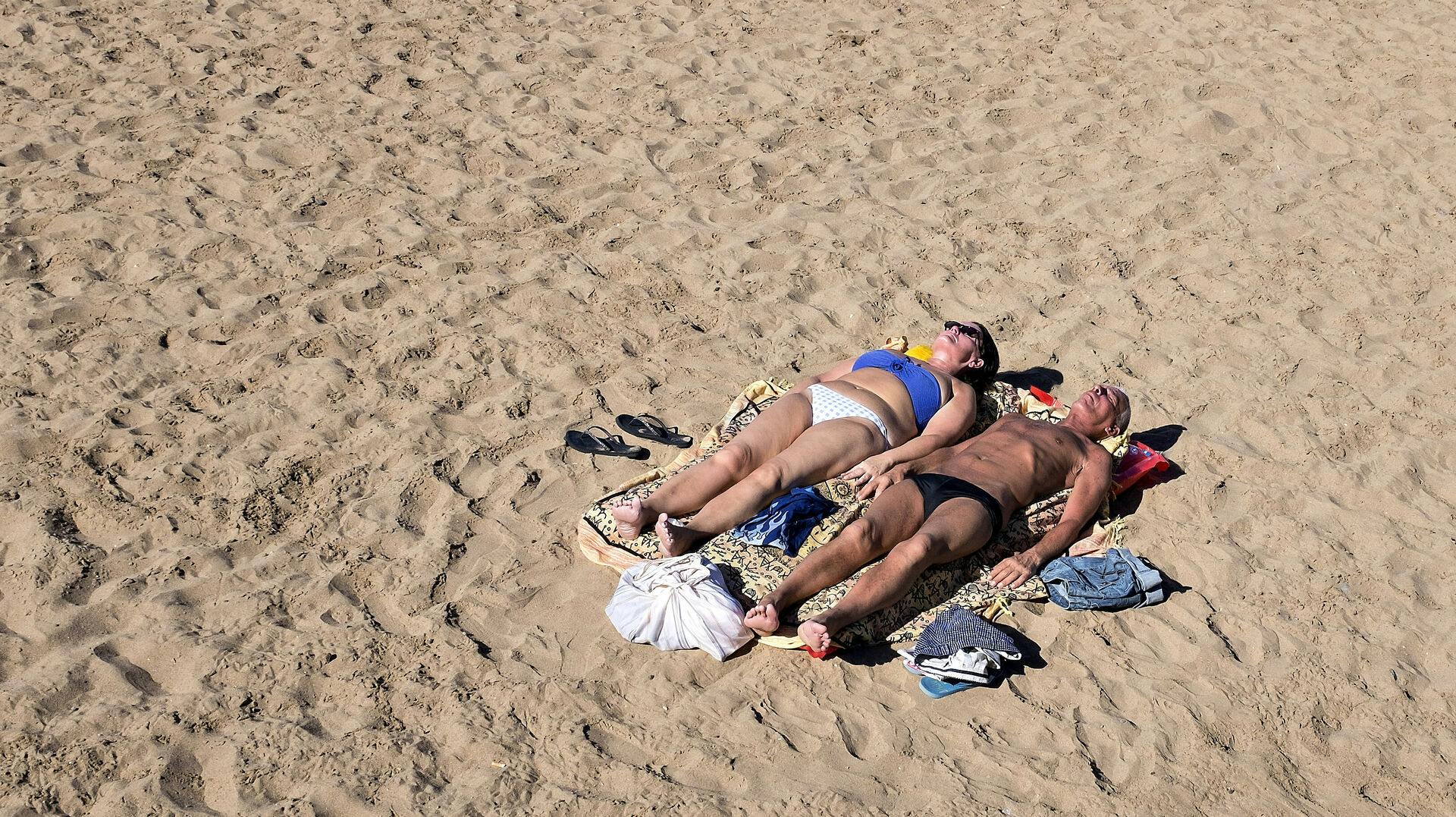 Mogan, Puerto de Mogan, lille havneby på sydkysten af Gran Canaria i Spanien, januar 2018. Stranden med solbrune turister i sandet