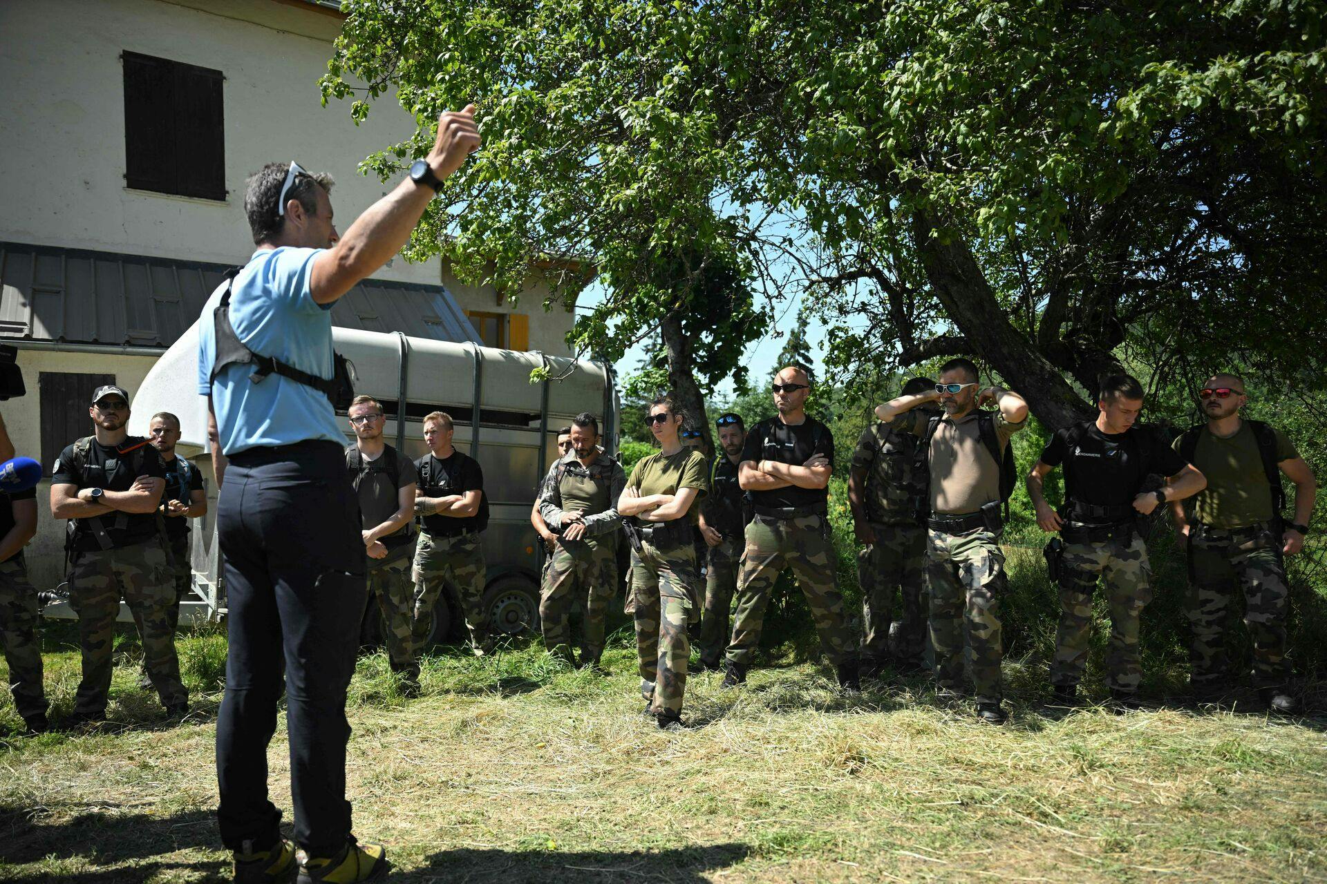 TOPSHOT - French gendarmes are briefed before taking part in a search operation for two-and-a-half-year-old Emile who is reported missing for two days, on July 10, 2023 in the French southern Alps village of Le Vernet. Emile was last seen playing in the garden at his grandparents' house on July 8, 2023. The scope of research has been extended, the Mayor said on Monday 10, 2023. (Photo by NICOLAS TUCAT / AFP)