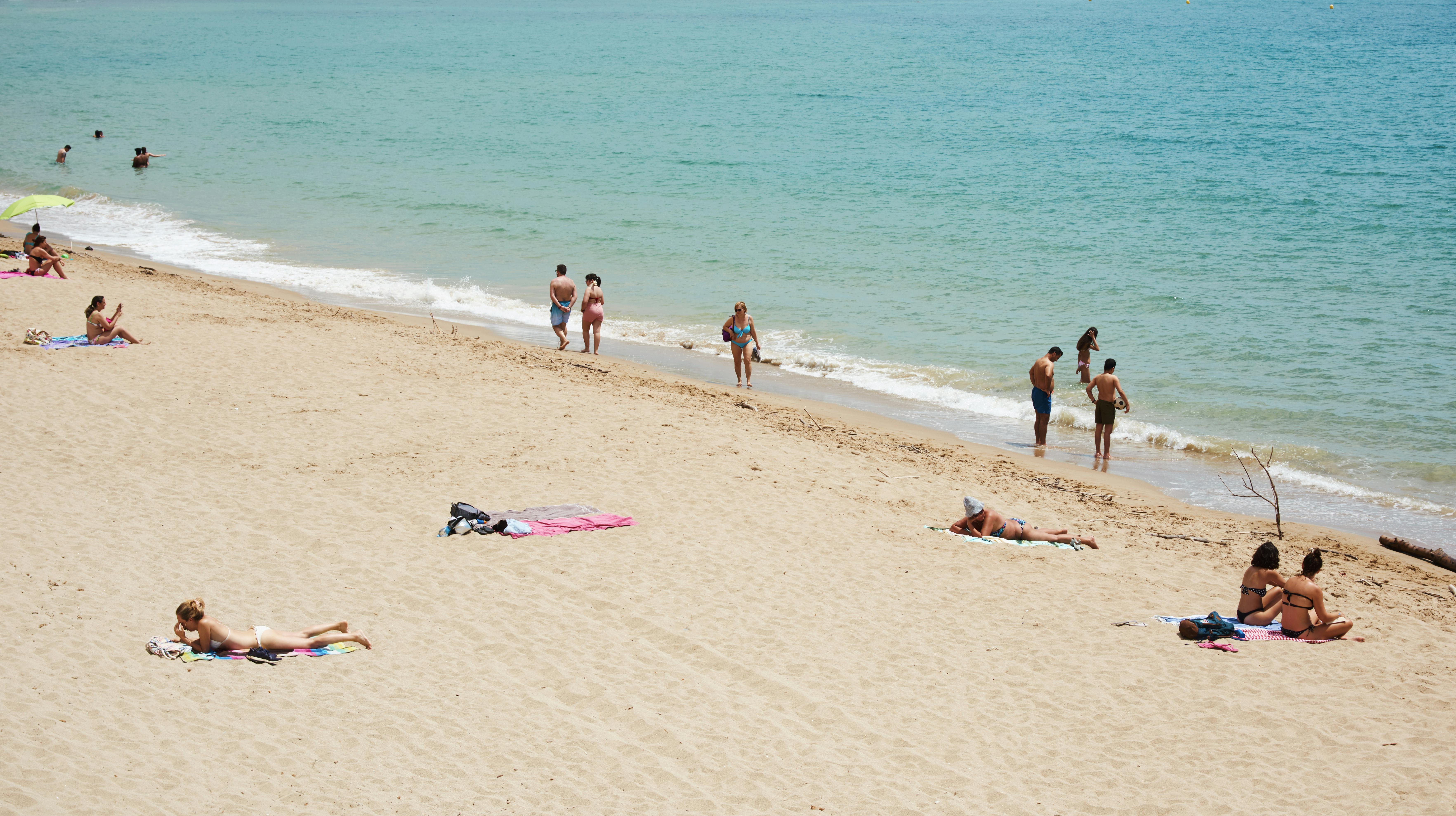 TARRAGONA, SPAIN - MAY 31, 2020: People enjoying at the Miracle Beach in Tarragona, in the second phase of the easing of the covid-19 restrictions, where people should keep a distance of 2 meters