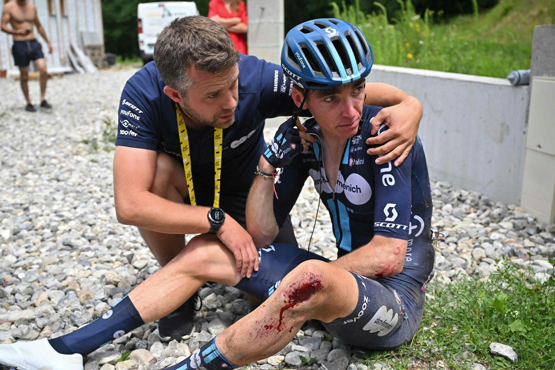 Romain Bardet bliver trøstet af en fra holdet, efter DSM-rytteren styrtede og måtte udgå.