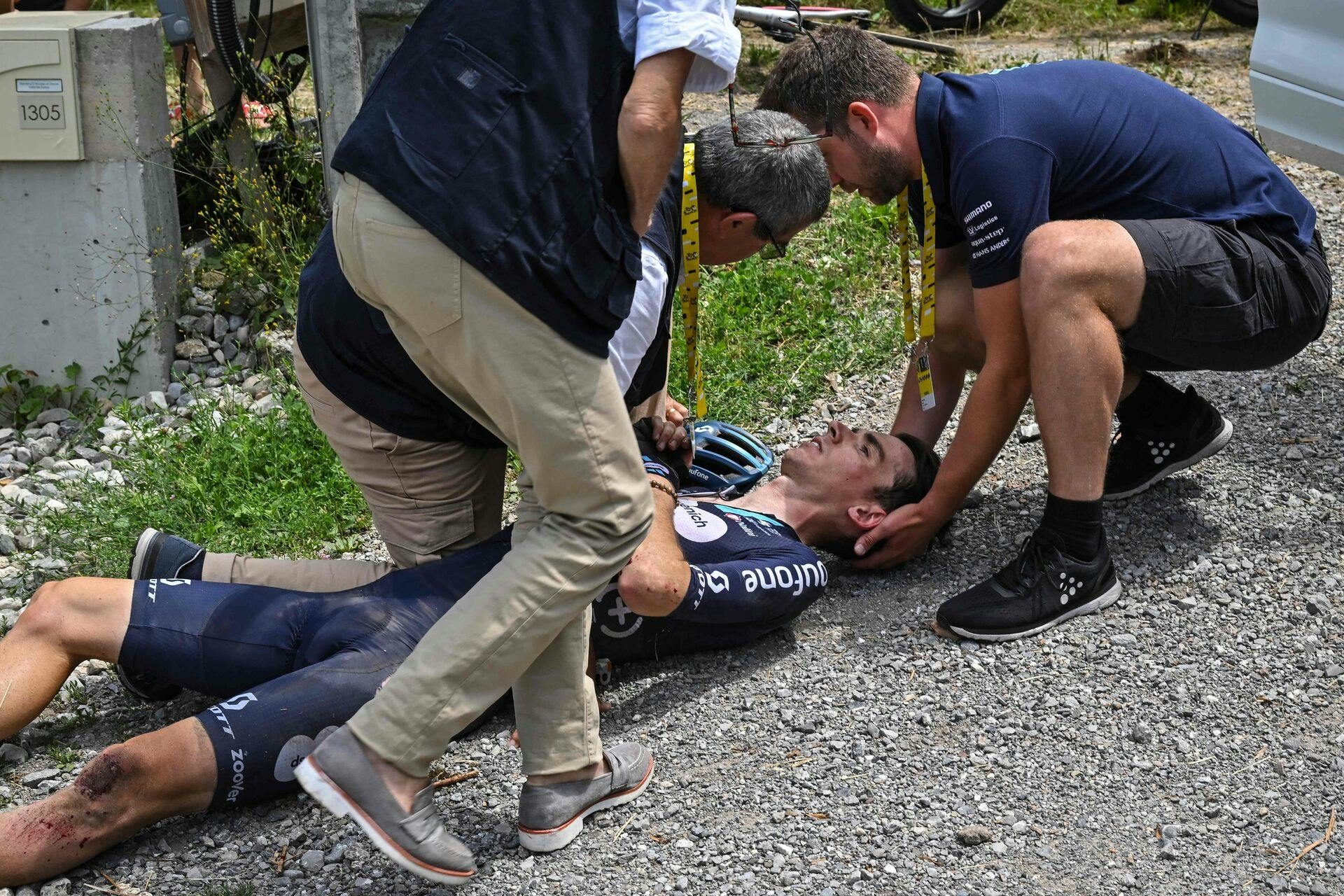 TOPSHOT - Team DSM - Firmenich's French rider Romain Bardet receives medical attention after a crash during the 14th stage of the 110th edition of the Tour de France cycling race, 152 km between Annemasse and Morzine Les Portes du Soleil, in the French Alps, on July 15, 2023. (Photo by Marco BERTORELLO / AFP)