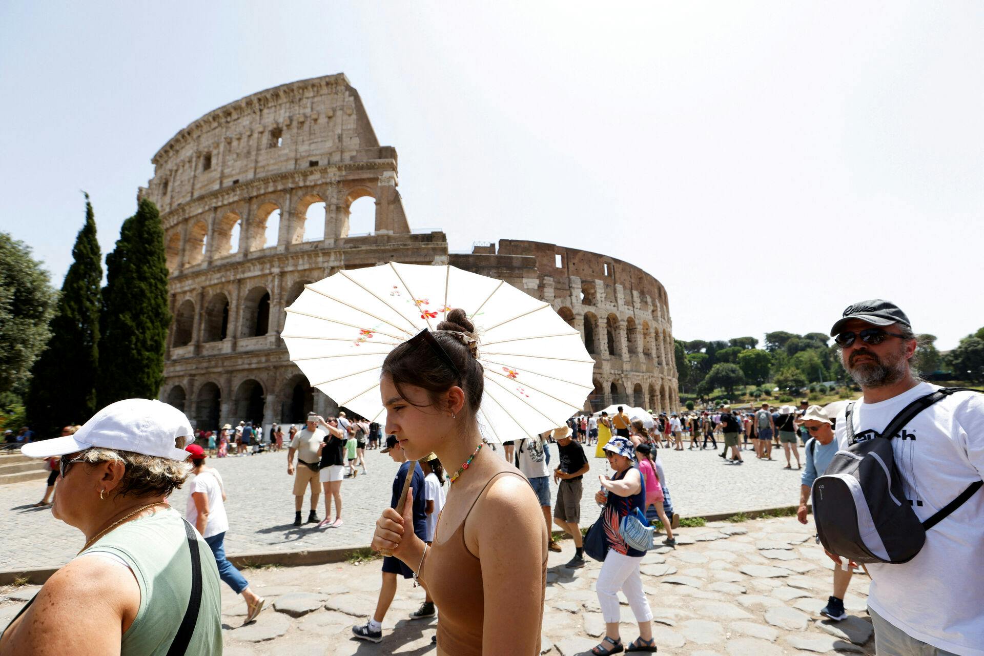 FILE PHOTO: People walk near the Colosseum during a heat wave across Italy as temperatures are expected to rise further in the coming days, in Rome, Italy July 17, 2023. REUTERS/Remo Casilli/File Photo