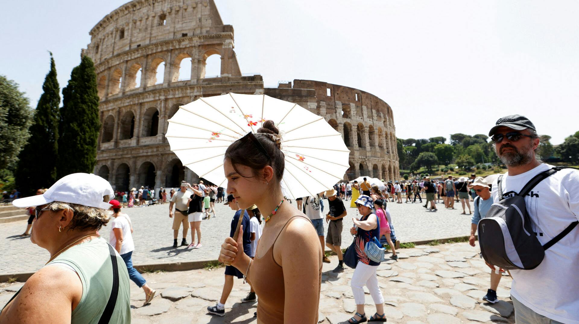 FILE PHOTO: People walk near the Colosseum during a heat wave across Italy as temperatures are expected to rise further in the coming days, in Rome, Italy July 17, 2023. REUTERS/Remo Casilli/File Photo