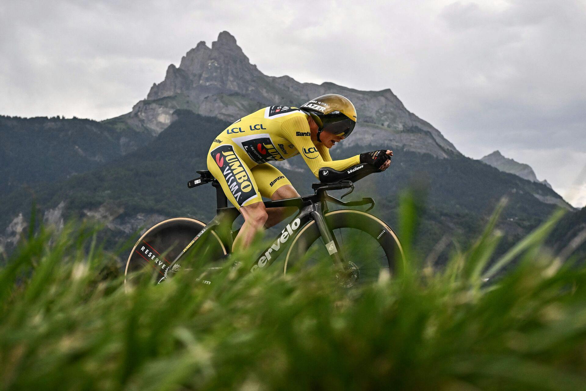 TOPSHOT - Jumbo-Visma's Danish rider Jonas Vingegaard wearing the overall leader's yellow jersey cycles during the 16th stage of the 110th edition of the Tour de France cycling race, 22 km individual time trial between Passy and Combloux, in the French Alps, on July 18, 2023. (Photo by Marco BERTORELLO / AFP)