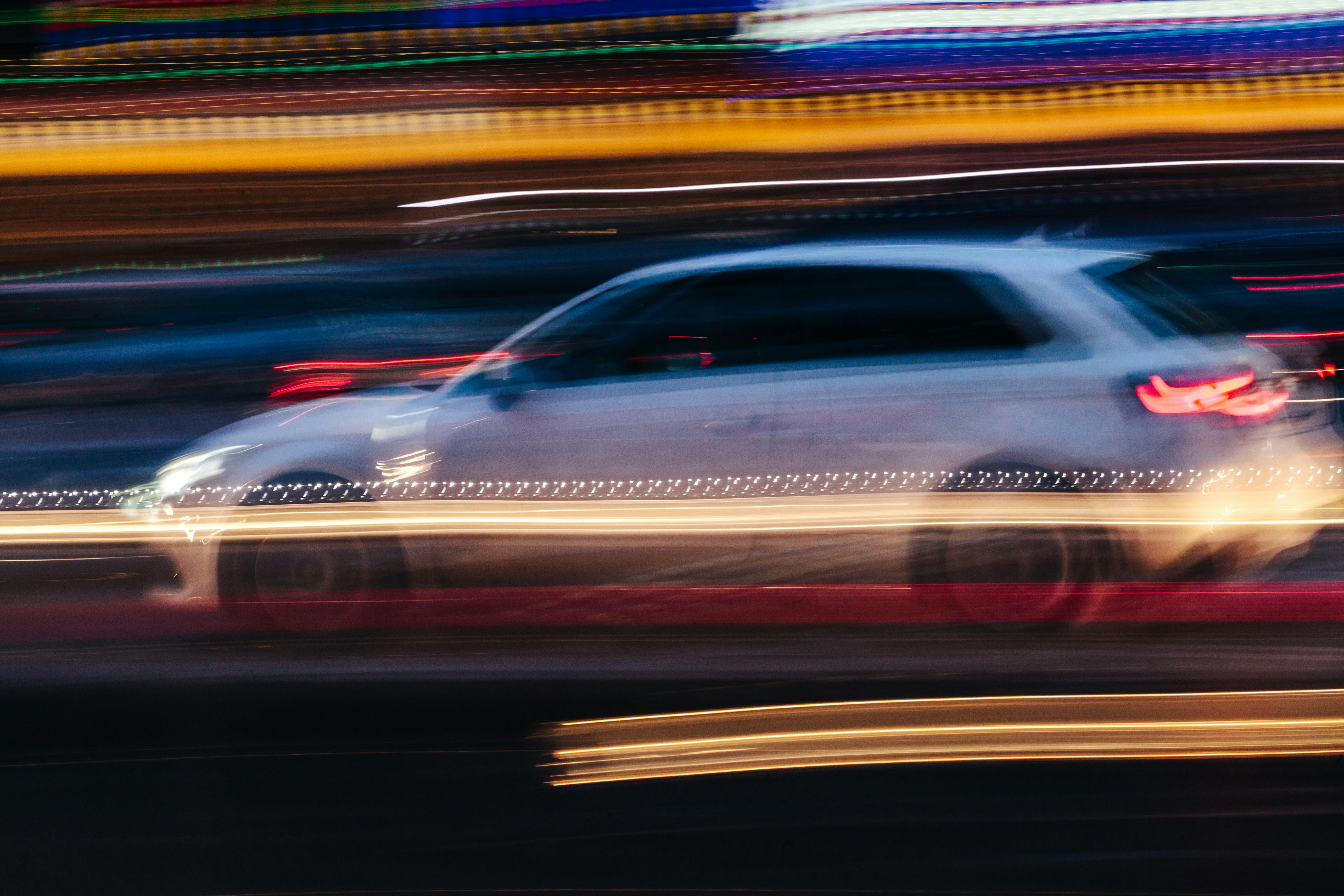 White Compact Car in a Blurred City Scene