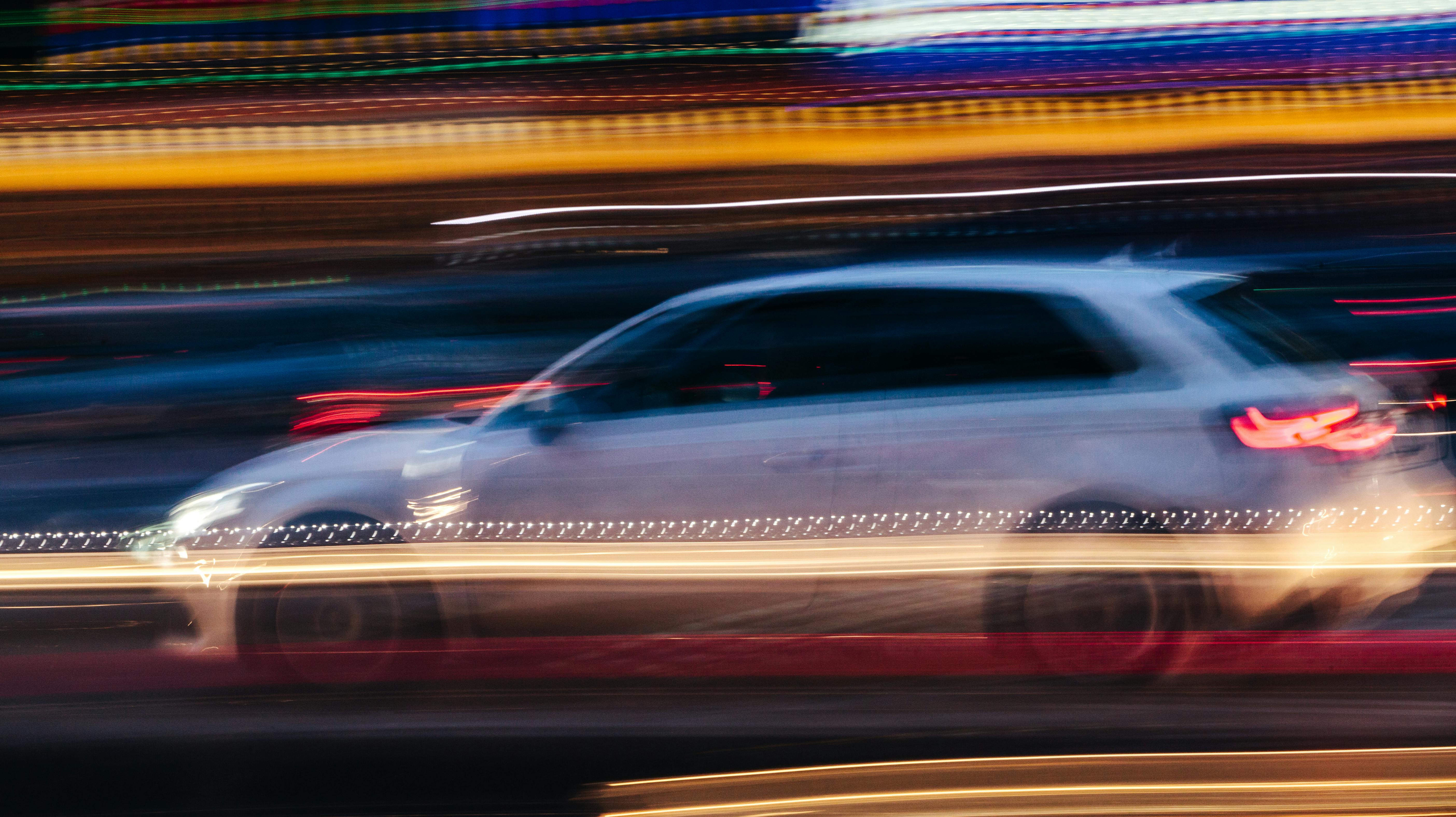 White Compact Car in a Blurred City Scene