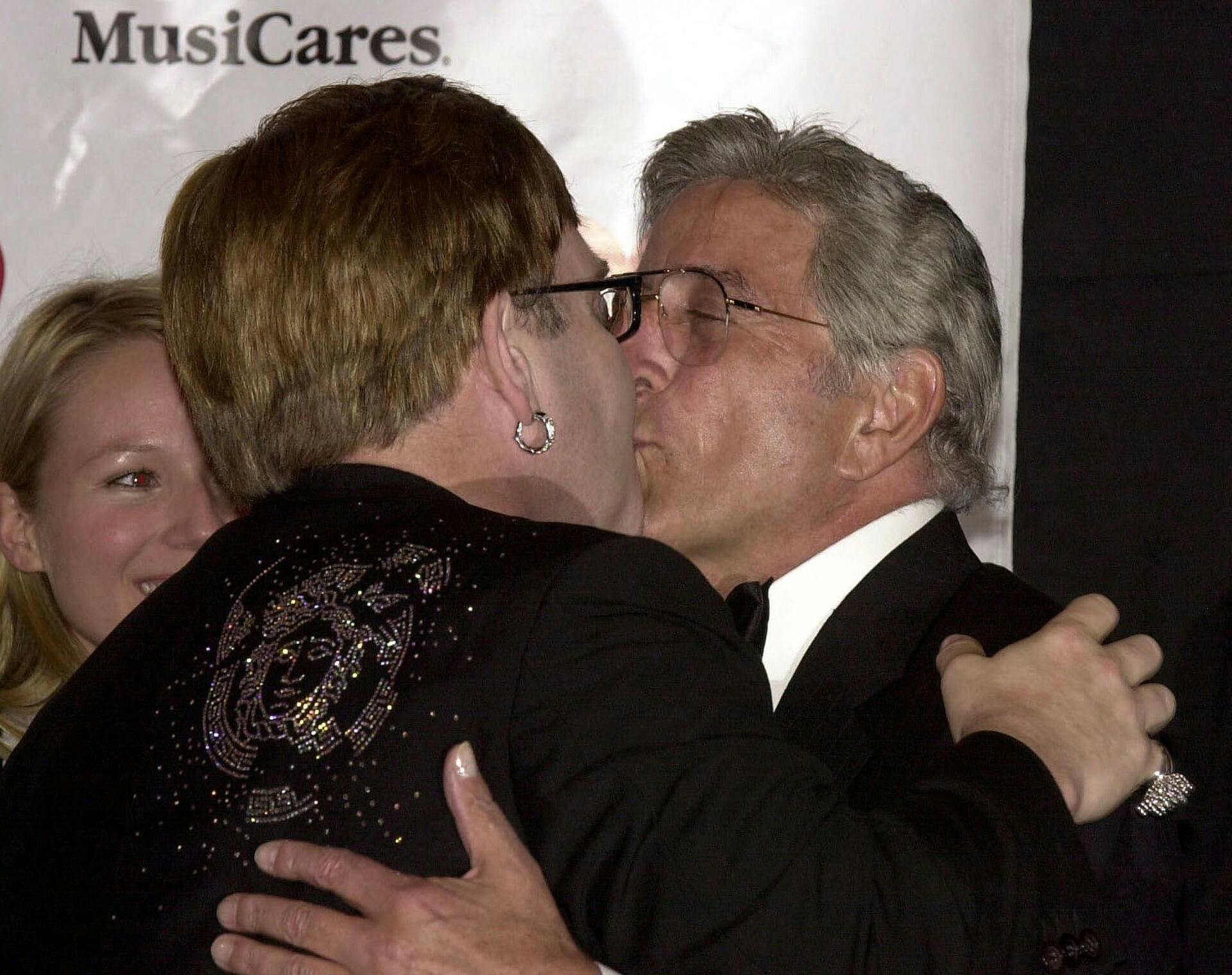 Sir Elton John (L) kisses singer Tony Bennett (R) during a ceremony honoring John with the MusiCares Person of the Year Award 21 February 2000 in Los Angeles, Ca. The benefit event included performances by Sting, Phil Collins, Bennett and Jewel(L). (ELECTRONIC IMAGE) AFP PHOTO VINCE BUCCI VINCE BUCCI / AFP