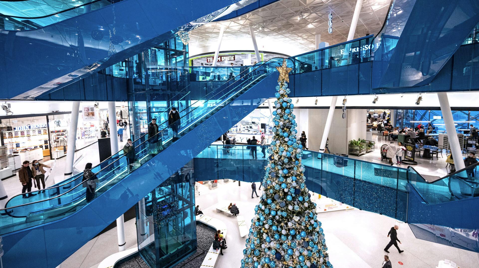 Christmas shoppers maintain social distancing as they ride on escalators in Emporia shopping centre in Malmo, Sweden, on December 20, 2020, amid the novel coronavirus / COVID-19 pandemic. Johan NILSSON / TT News Agency / AFP