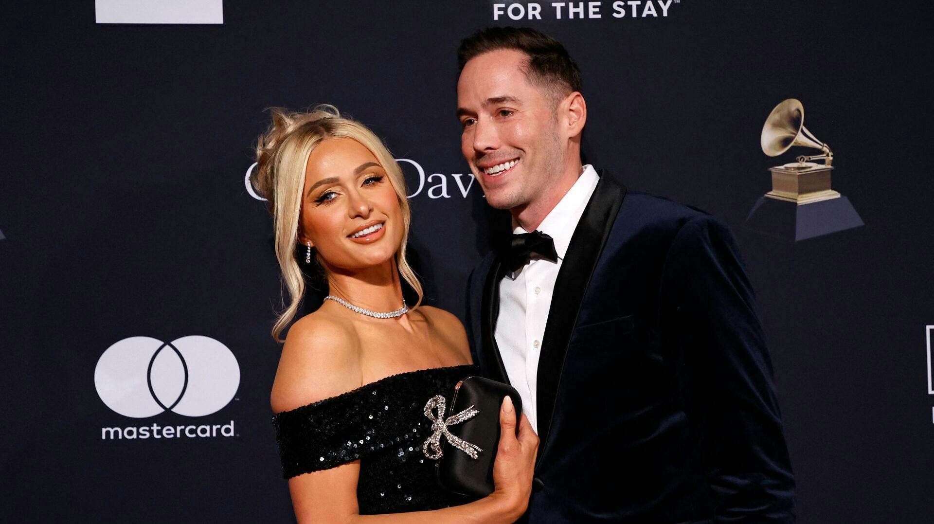 US socialite Paris Hilton (L) and husband US author Carter Reum arrive for the Recording Academy and Clive Davis pre-Grammy gala at the Beverly Hilton hotel in Beverly Hills, California on February 4, 2023. (Photo by Michael TRAN / AFP)
