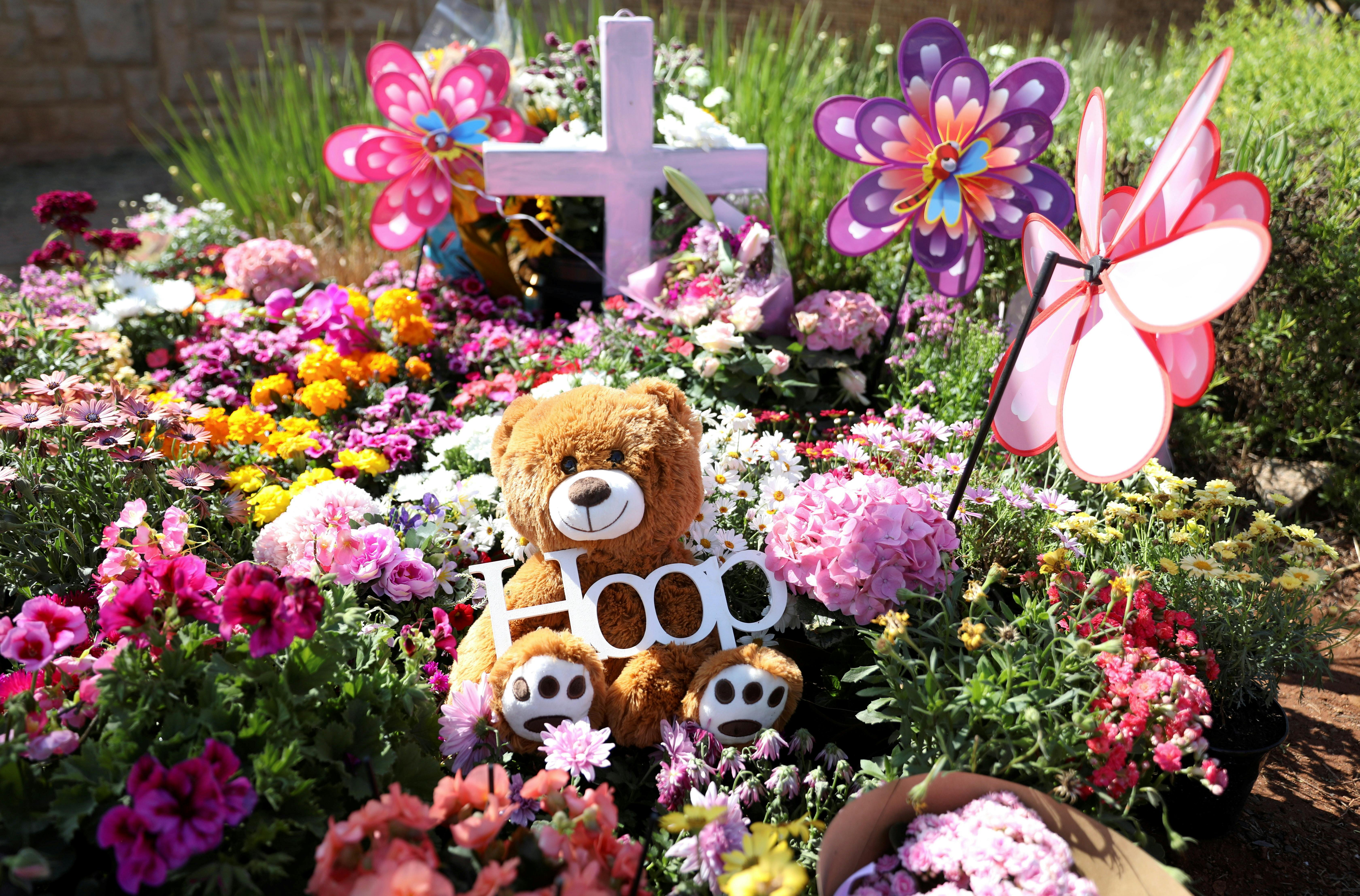 A teddy bear is seen among flowers placed outside where Lauren Anne Dickason, a woman charged with murdering her three young daughters just weeks after arriving in New Zealand from South Africa, used to live, in Pretoria, South Africa, September 24, 2021. REUTERS/Siphiwe Sibeko